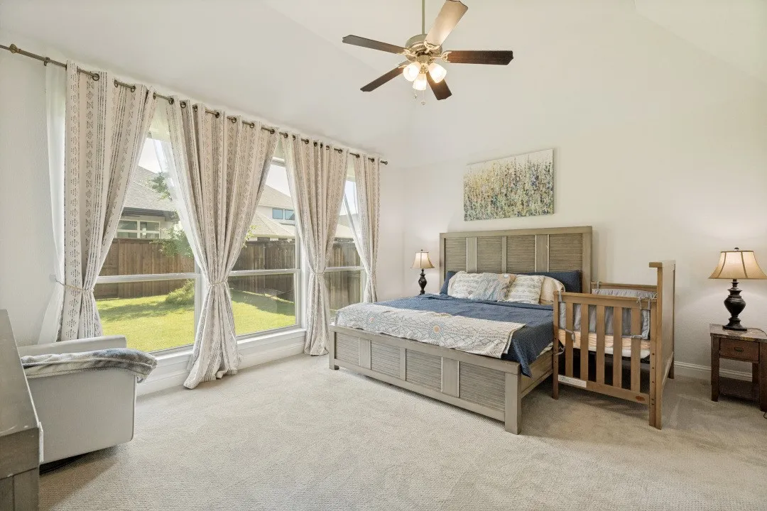 Carpeted room featuring a vaulted ceiling with a ceiling fan