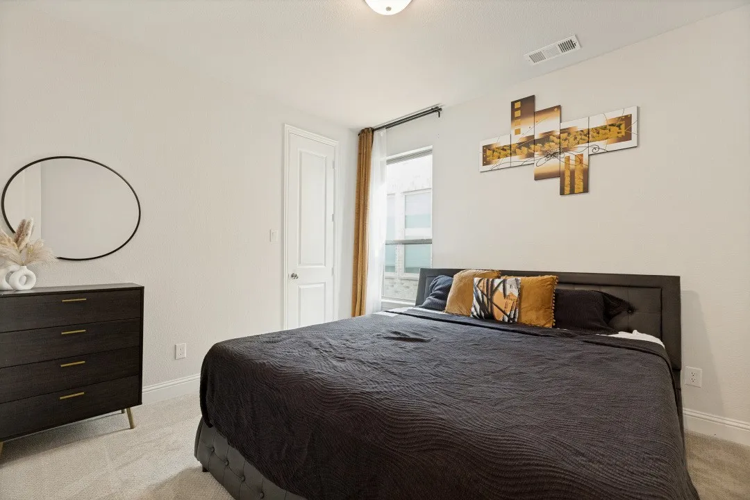 Bedroom featuring light-colored walls, a single window with curtain rods, white trim, and light gray carpeting