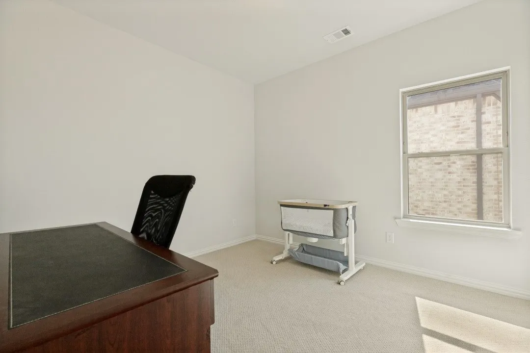 Bright room featuring a single window with white trim, light-colored carpeting, and neutral wall paint