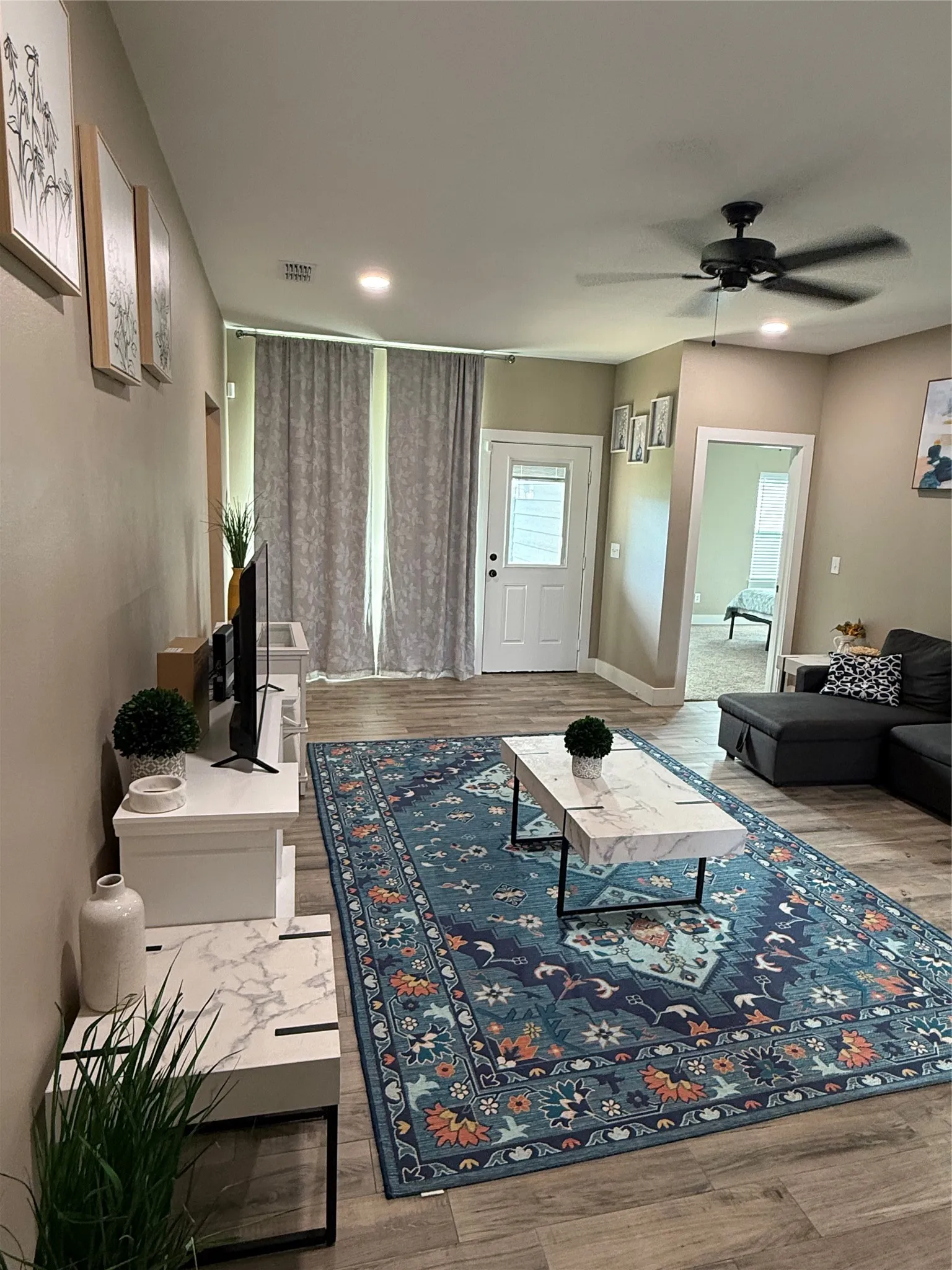 Open-concept living area featuring wood-finish flooring, recessed lighting, and a ceiling fan