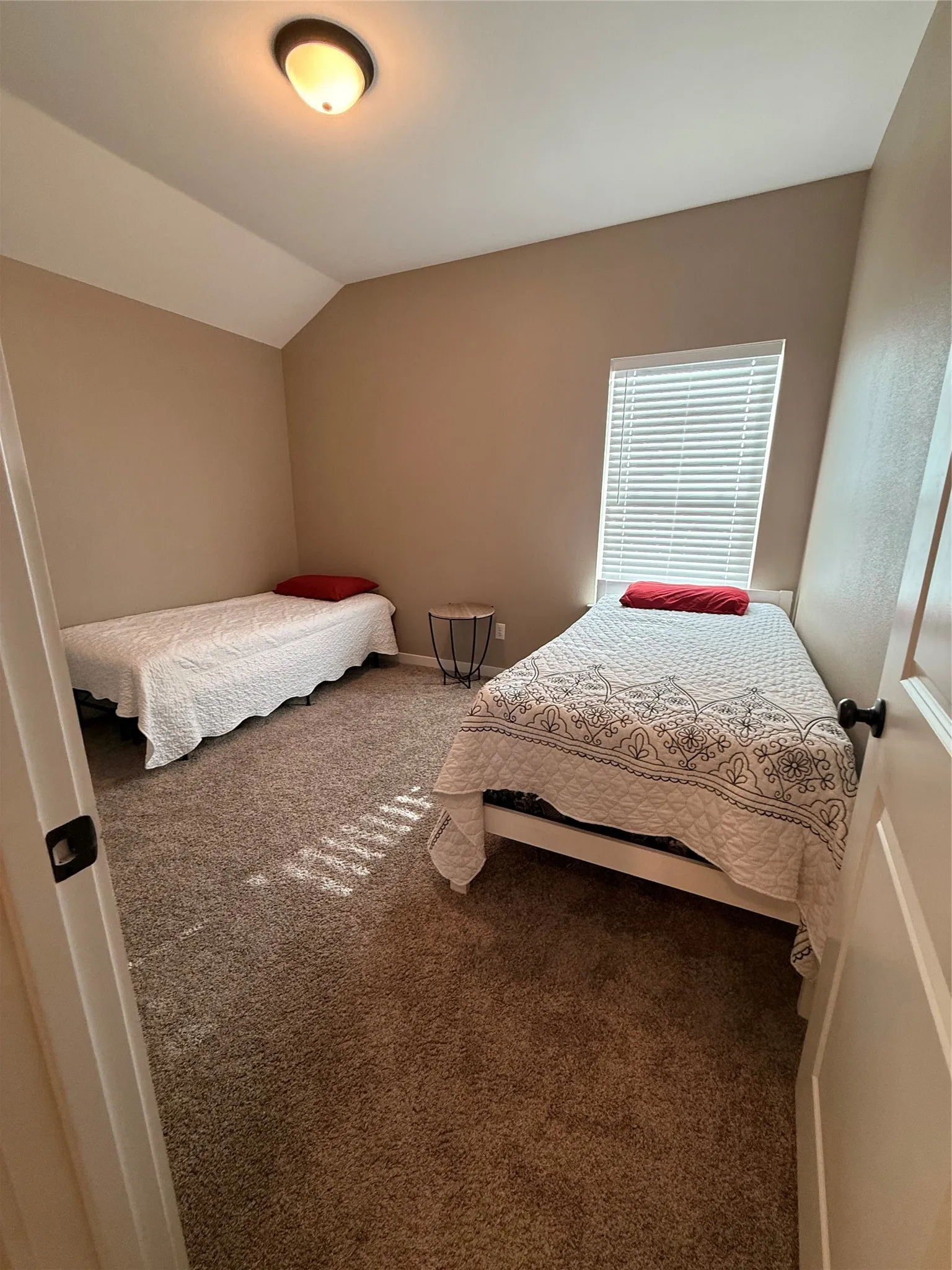 Room featuring neutral-toned walls, plush brown carpeting, and a window with horizontal blinds