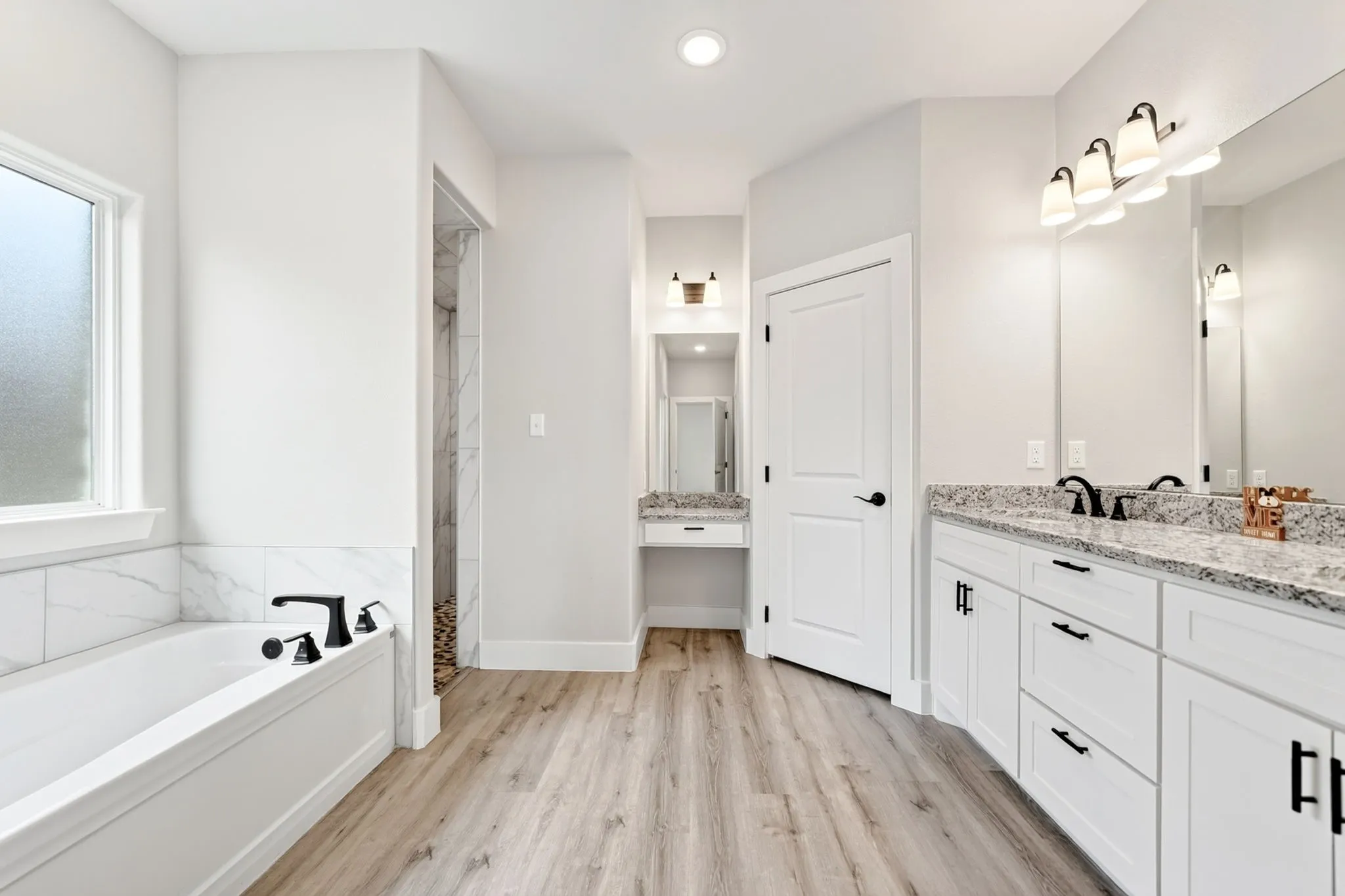 Spacious bathroom featuring light wood-finish flooring