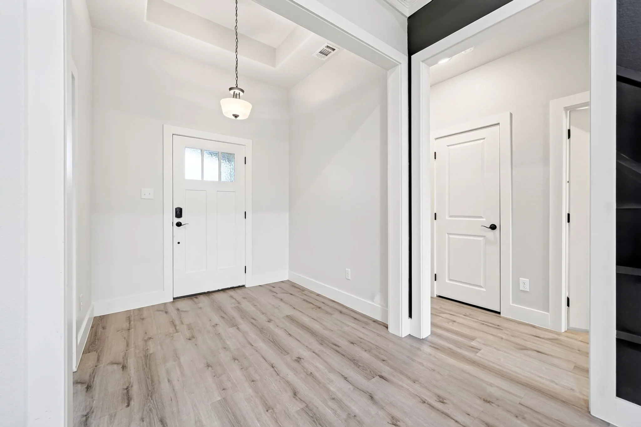 Entryway featuring light wood-finish flooring and white baseboards