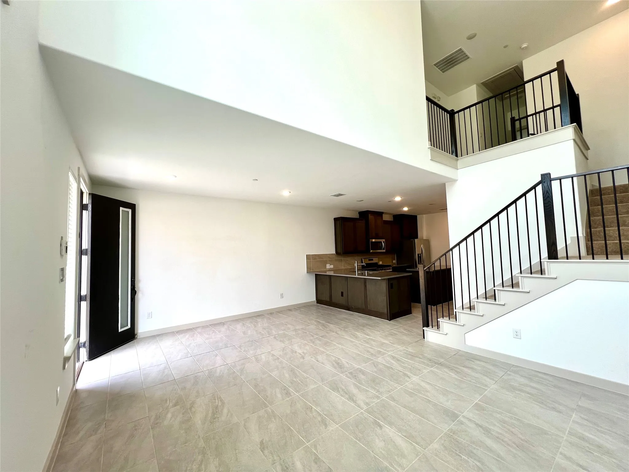 Unfurnished living room featuring a towering ceiling