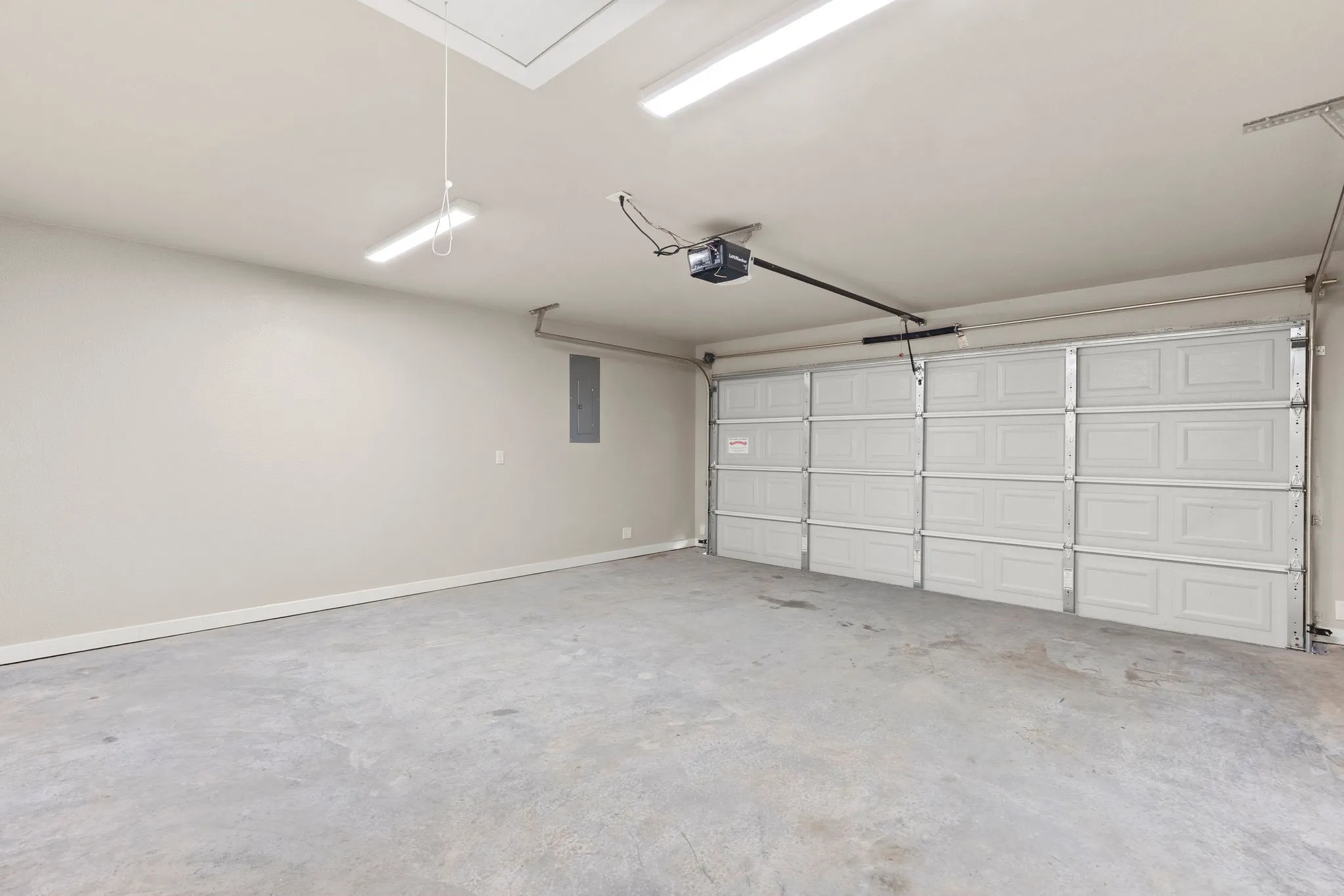 Finished-out Garage with electric panel and a garage door opener