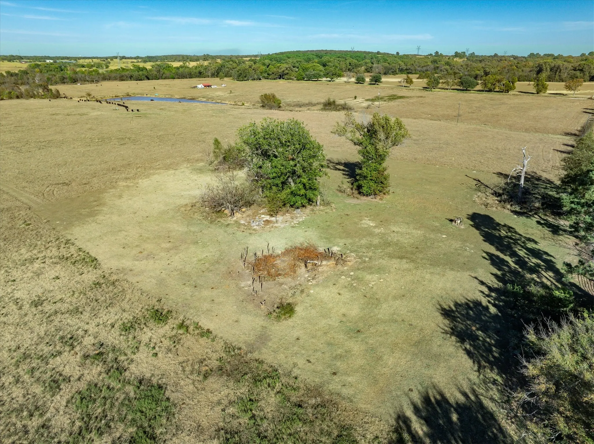 Expansive rural landscape featuring a natural pond and varied topography