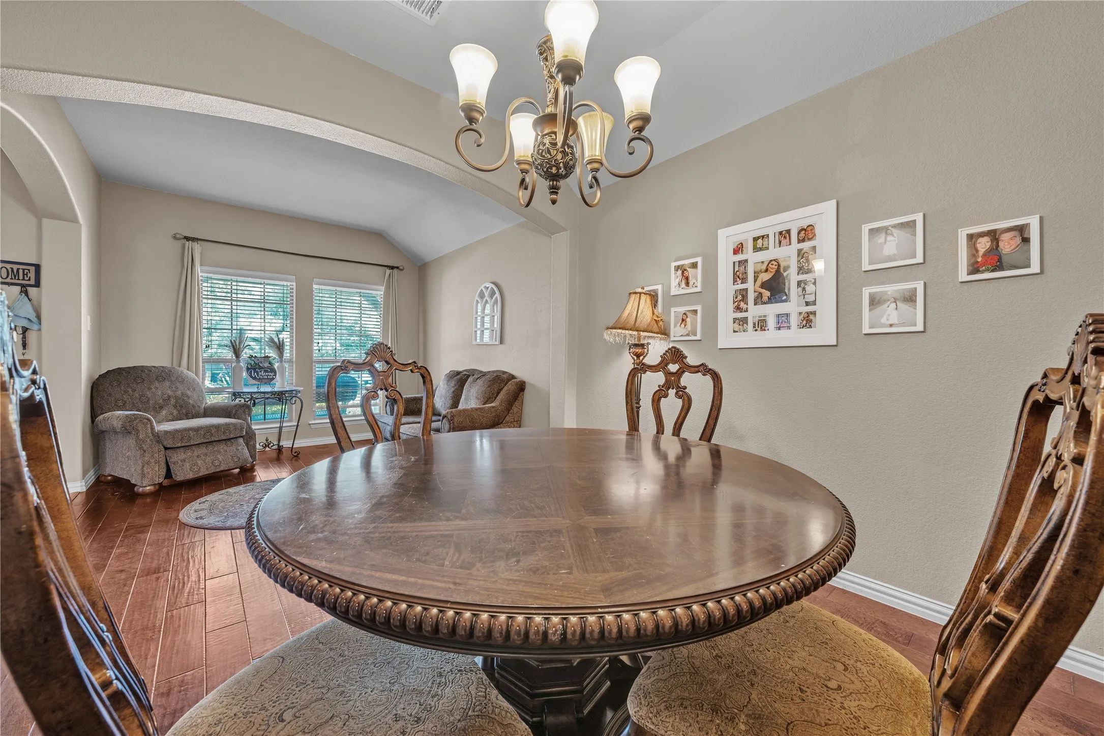 Formal dining space featuring wood-finish flooring and an arched entryway