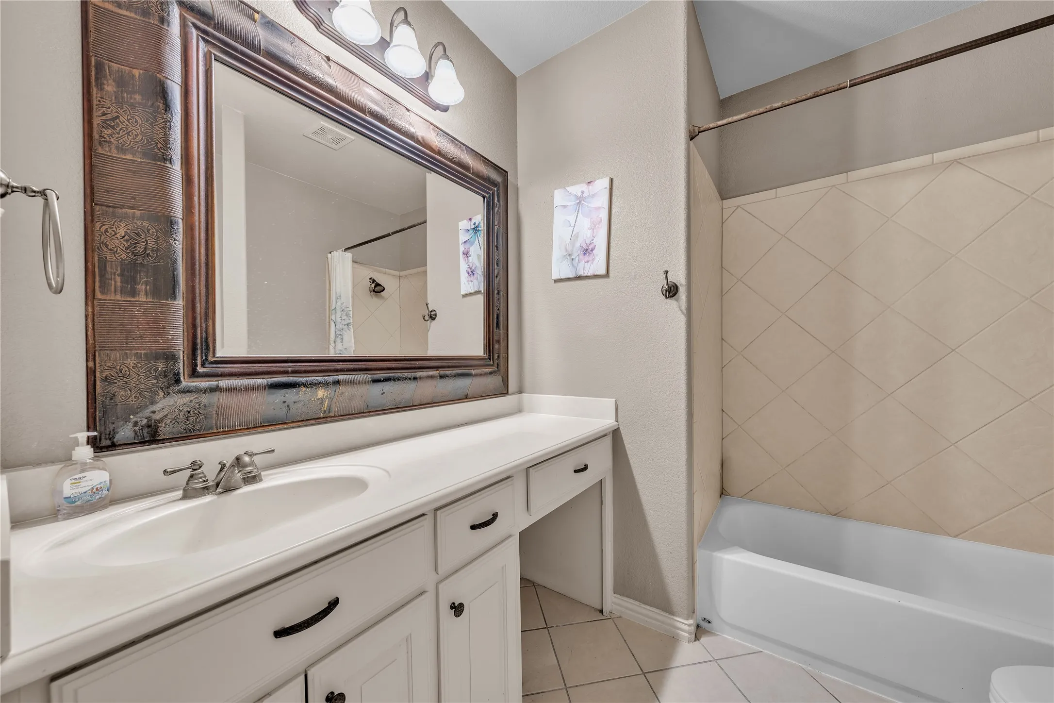 Bathroom vanity featuring an integrated sink with a dual-handle faucet, a spacious countertop, and white cabinetry
