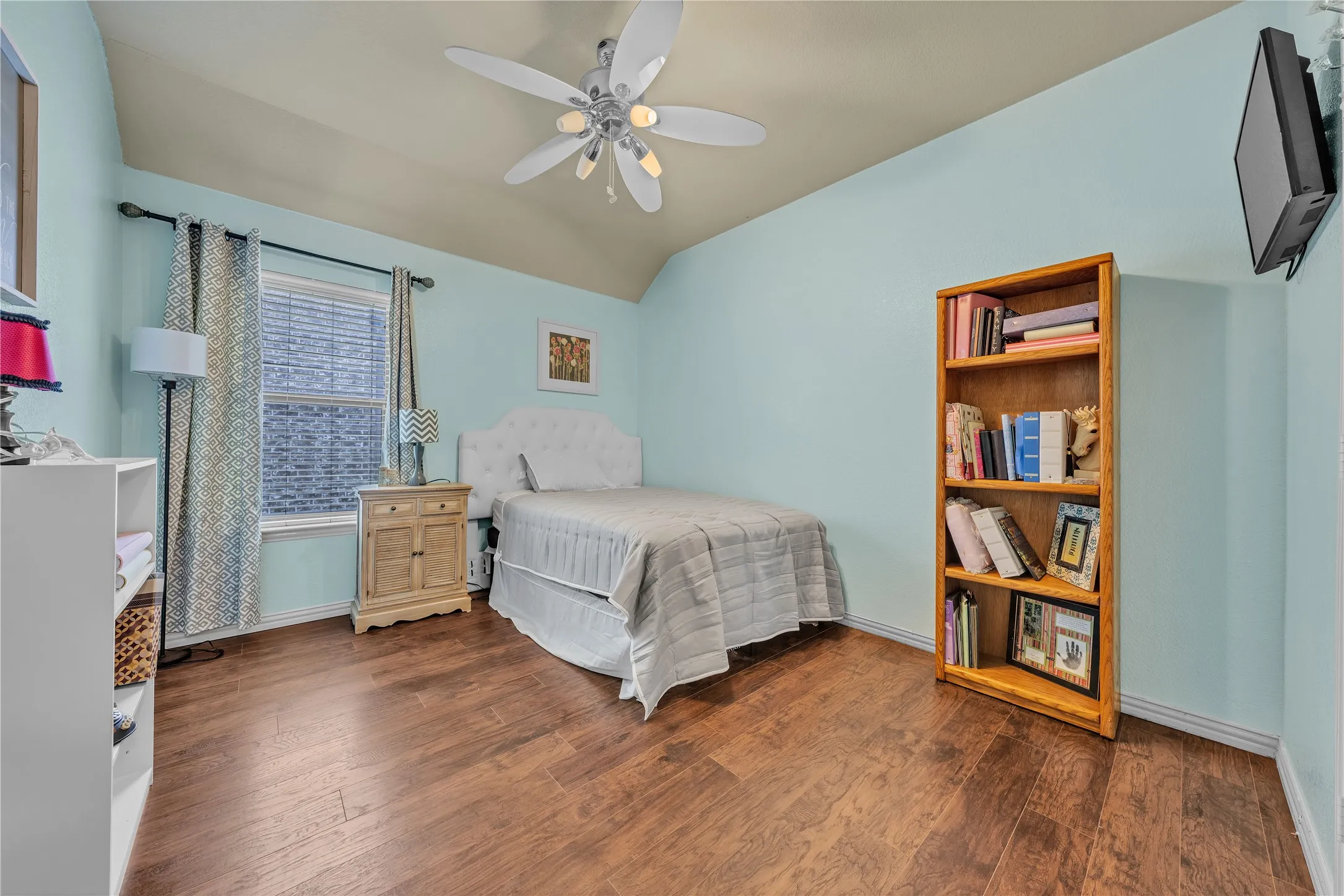 Room featuring wood-finish flooring, a window with horizontal blinds, and a ceiling fan with integrated lighting