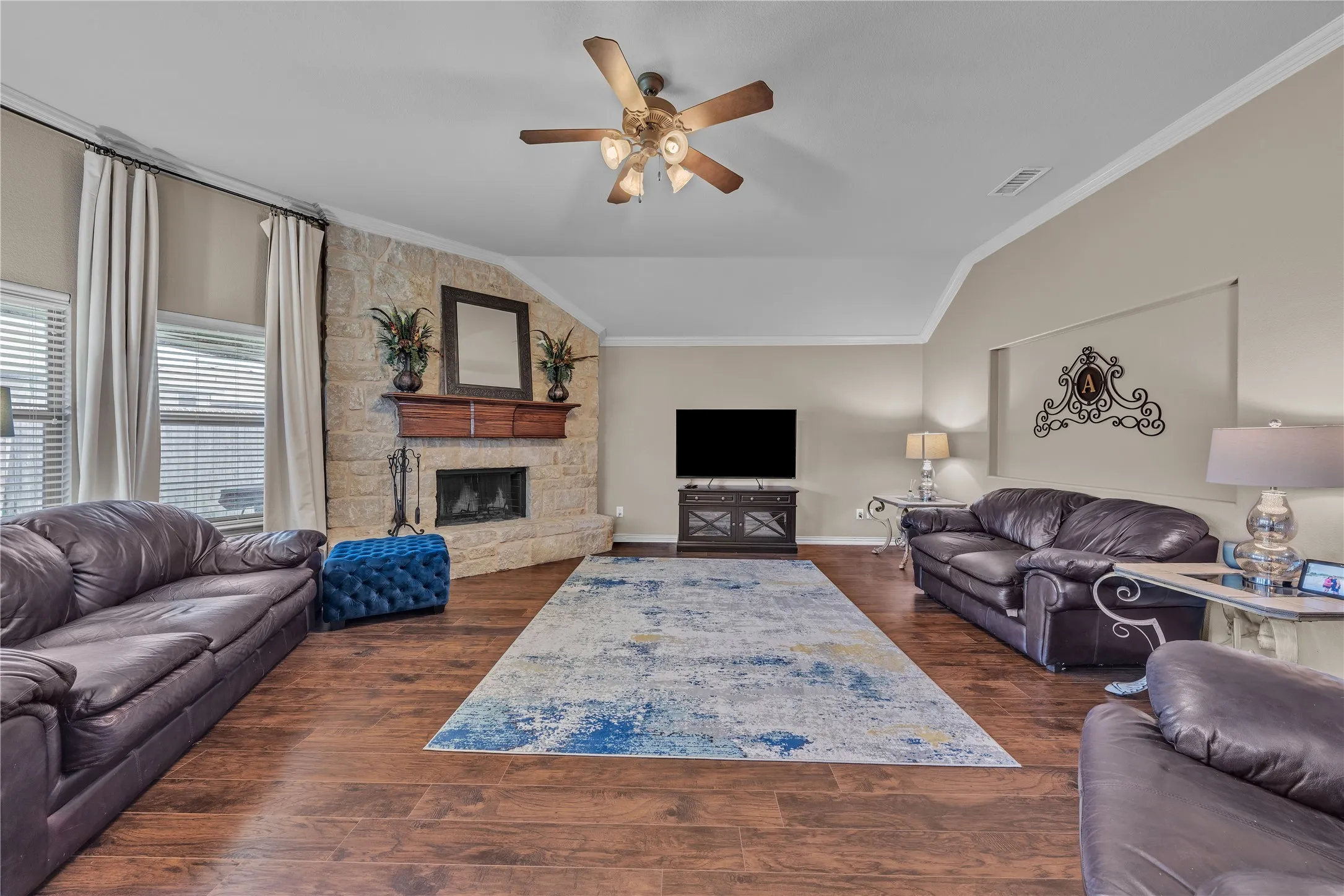 Spacious living area featuring wood-finish flooring and a vaulted ceiling