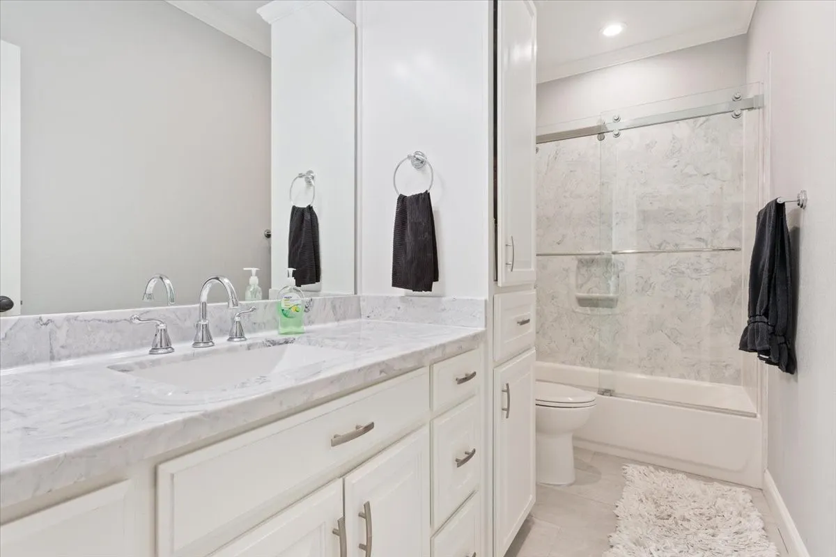 Bathroom featuring a white vanity with a light-toned countertop, an undermount sink, and polished chrome fixtures