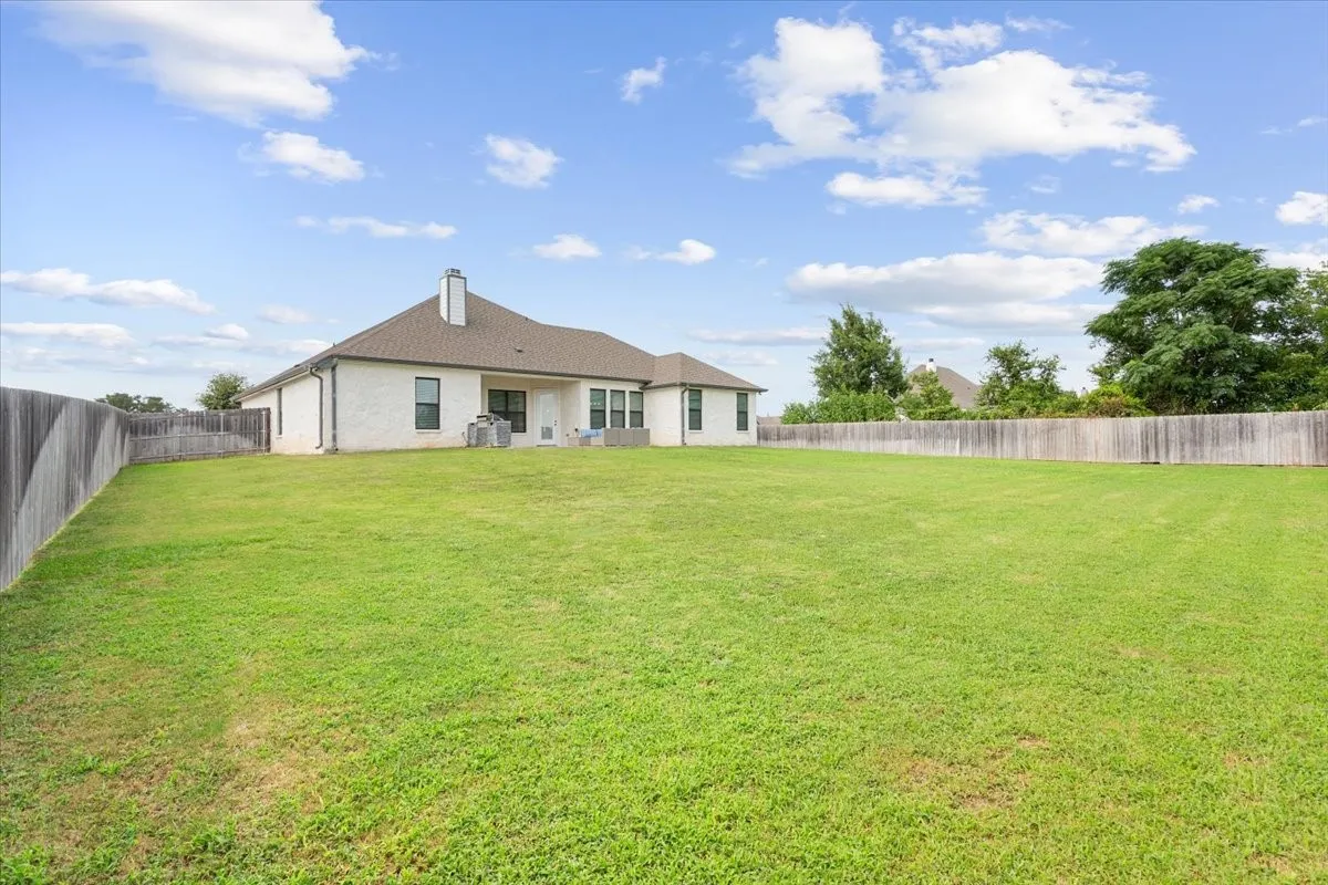 Expansive, fenced backyard featuring a generous lawn area