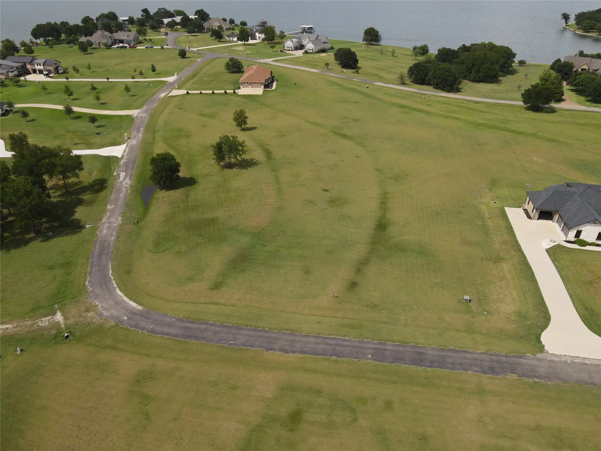 Expansive green lot with established paved road frontage and proximity to waterfront properties