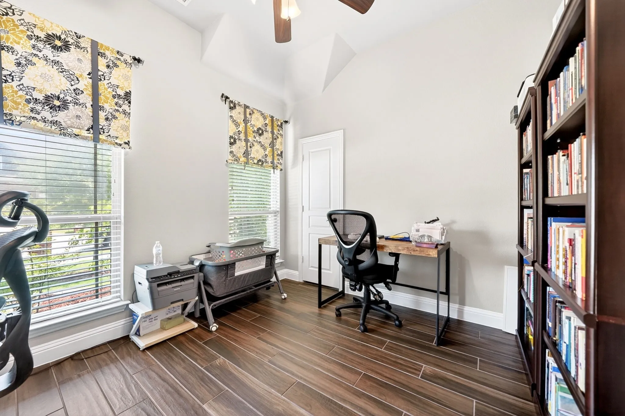 Spacious room featuring vaulted ceilings and wood-finish flooring
