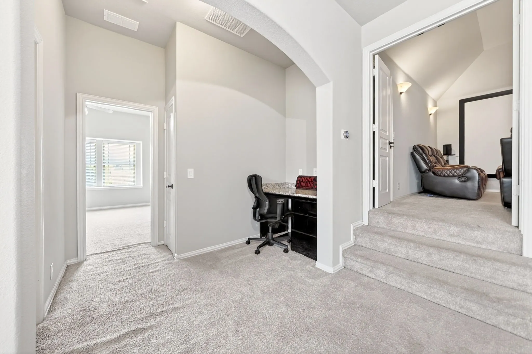 Upper level landing featuring carpeted flooring and an integrated desk nook with a stone-finish countertop