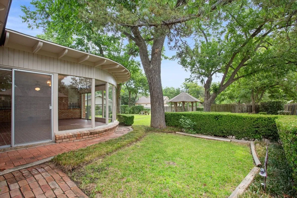 Side yard view of sun room and gazebo