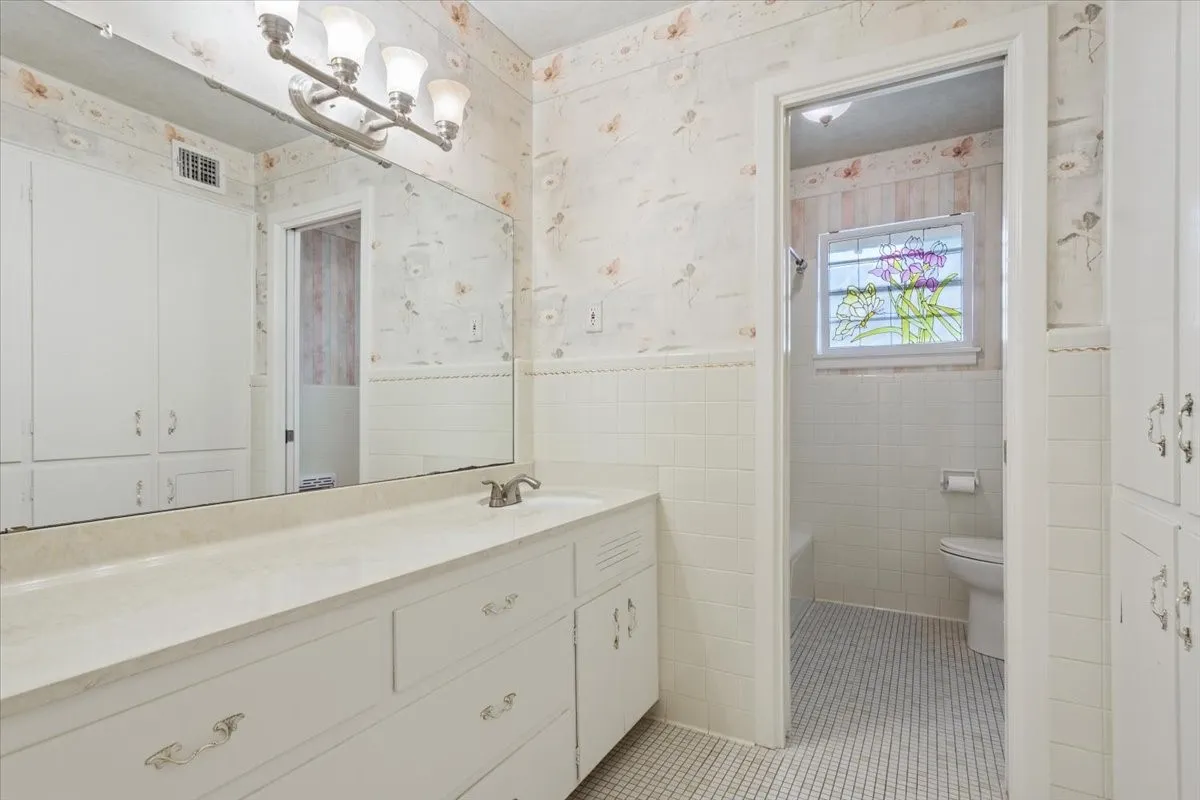 Second bathroom with original cabinets and tile