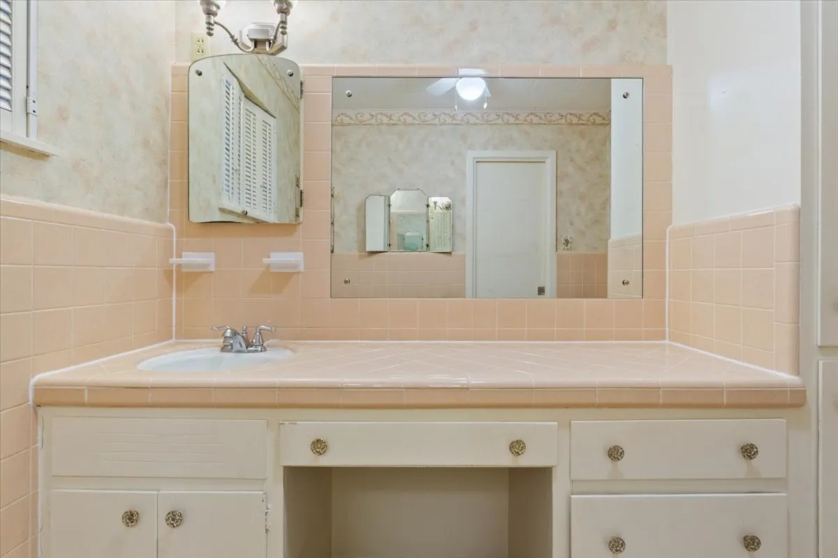 Primary bathroom with original cabinets and tile in excellent condition