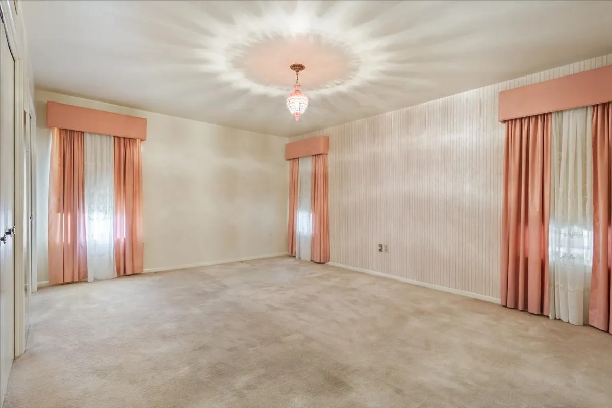 Large primary bedroom with walk in closet and original light fixture
