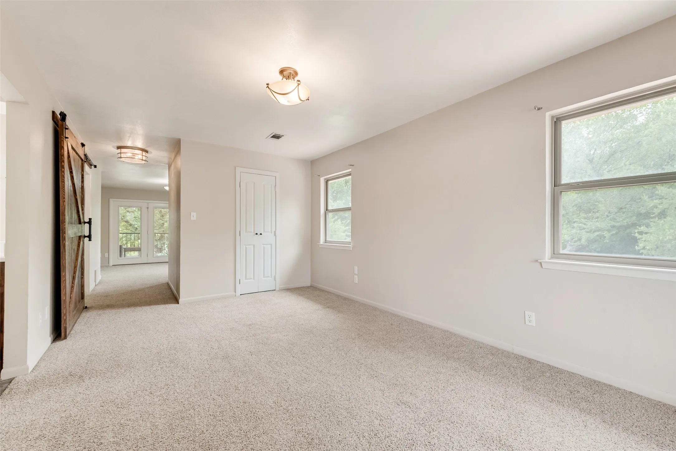 Primary room with barn doors that provide privacy from other bedrooms. Library study and balcony attached.