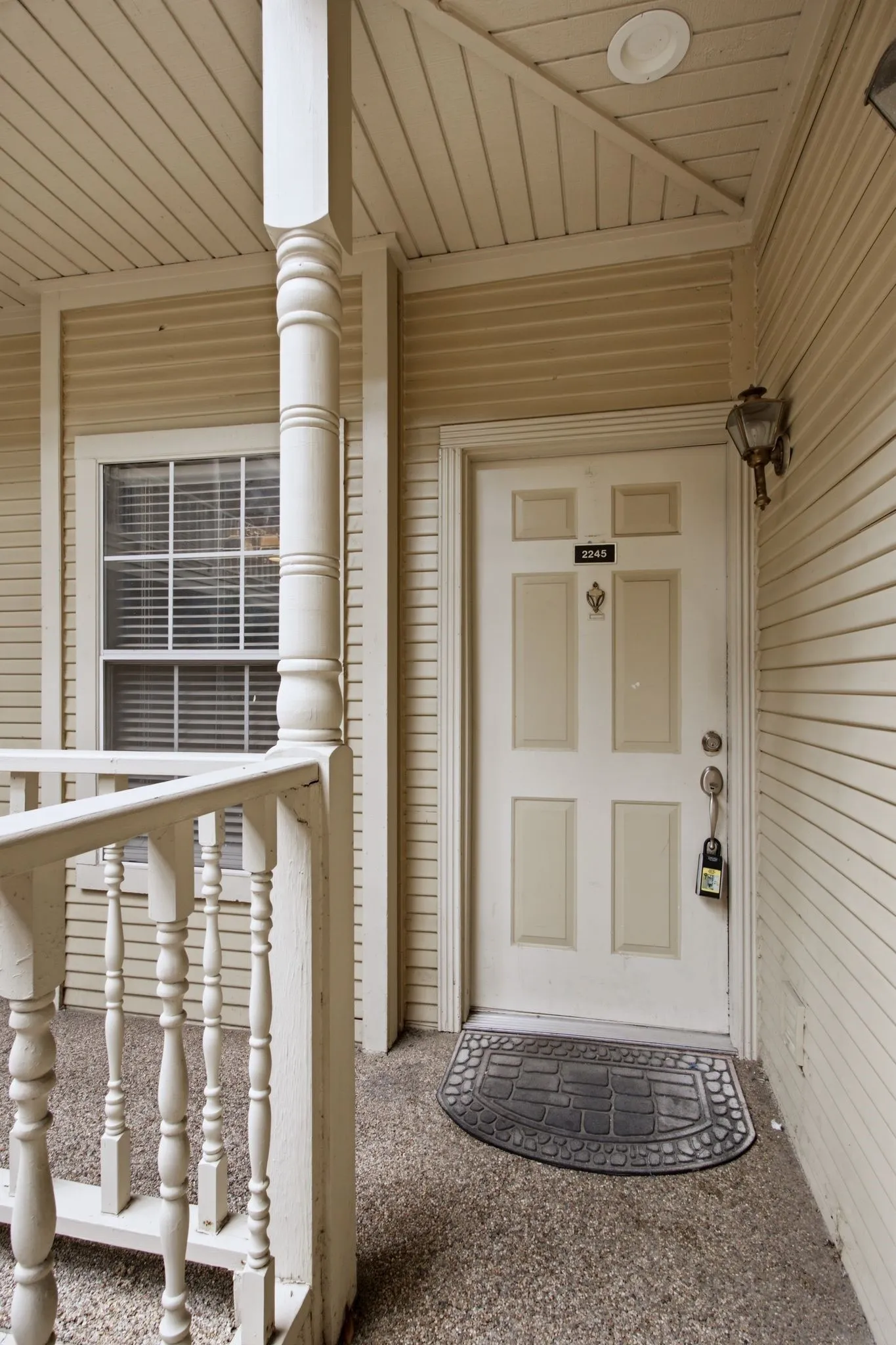 Entryway featuring a four-panel door with brass hardware, an exterior wall sconce, and recessed ceiling lighting