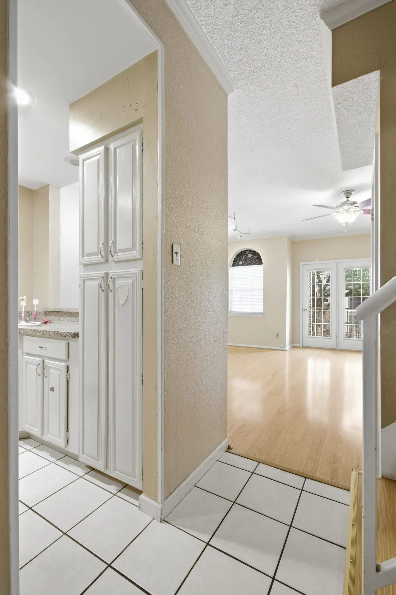 Kitchen area featuring white cabinetry, a light-toned countertop, and square tile flooring