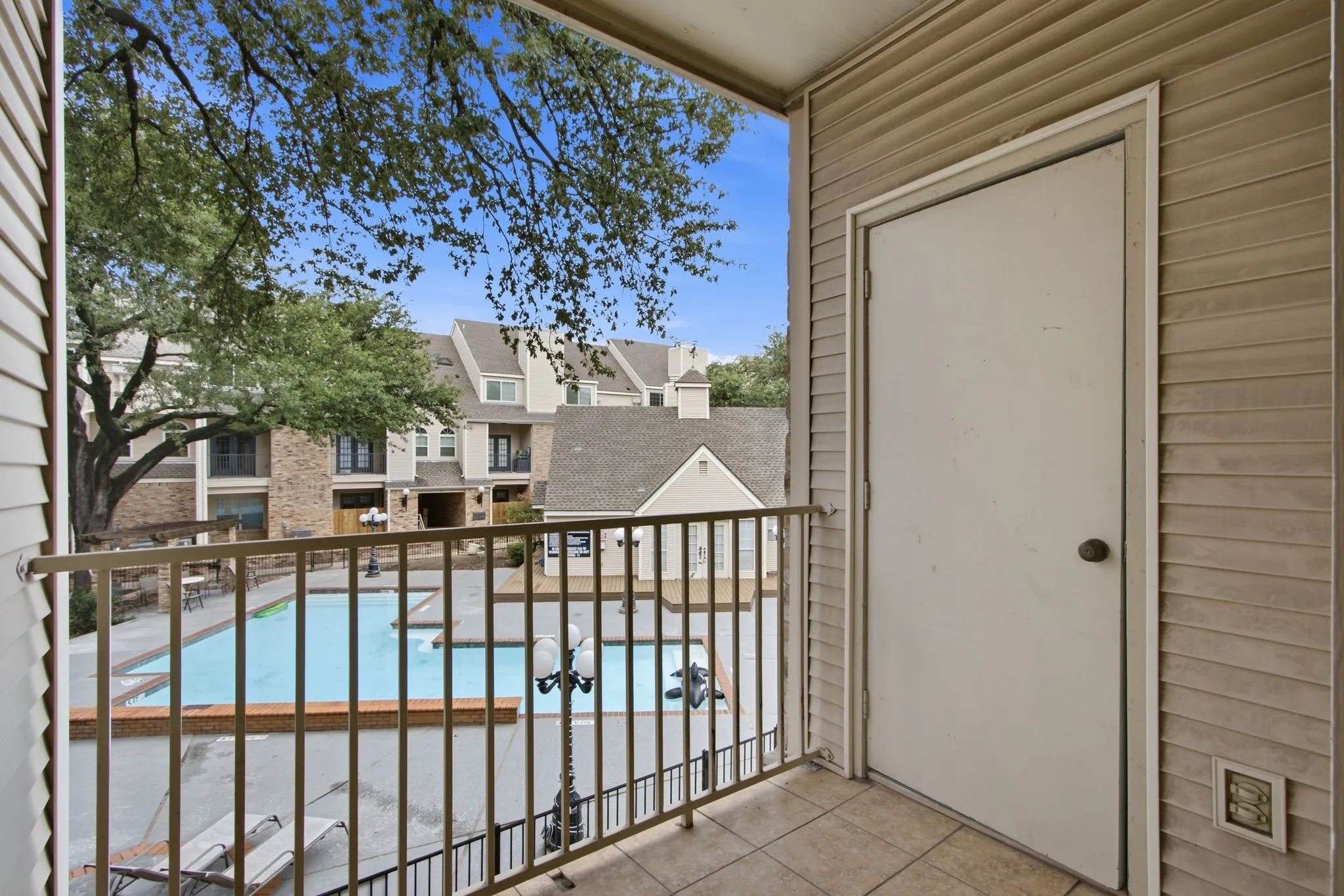 Balcony with ceramic tile flooring and tan siding exterior