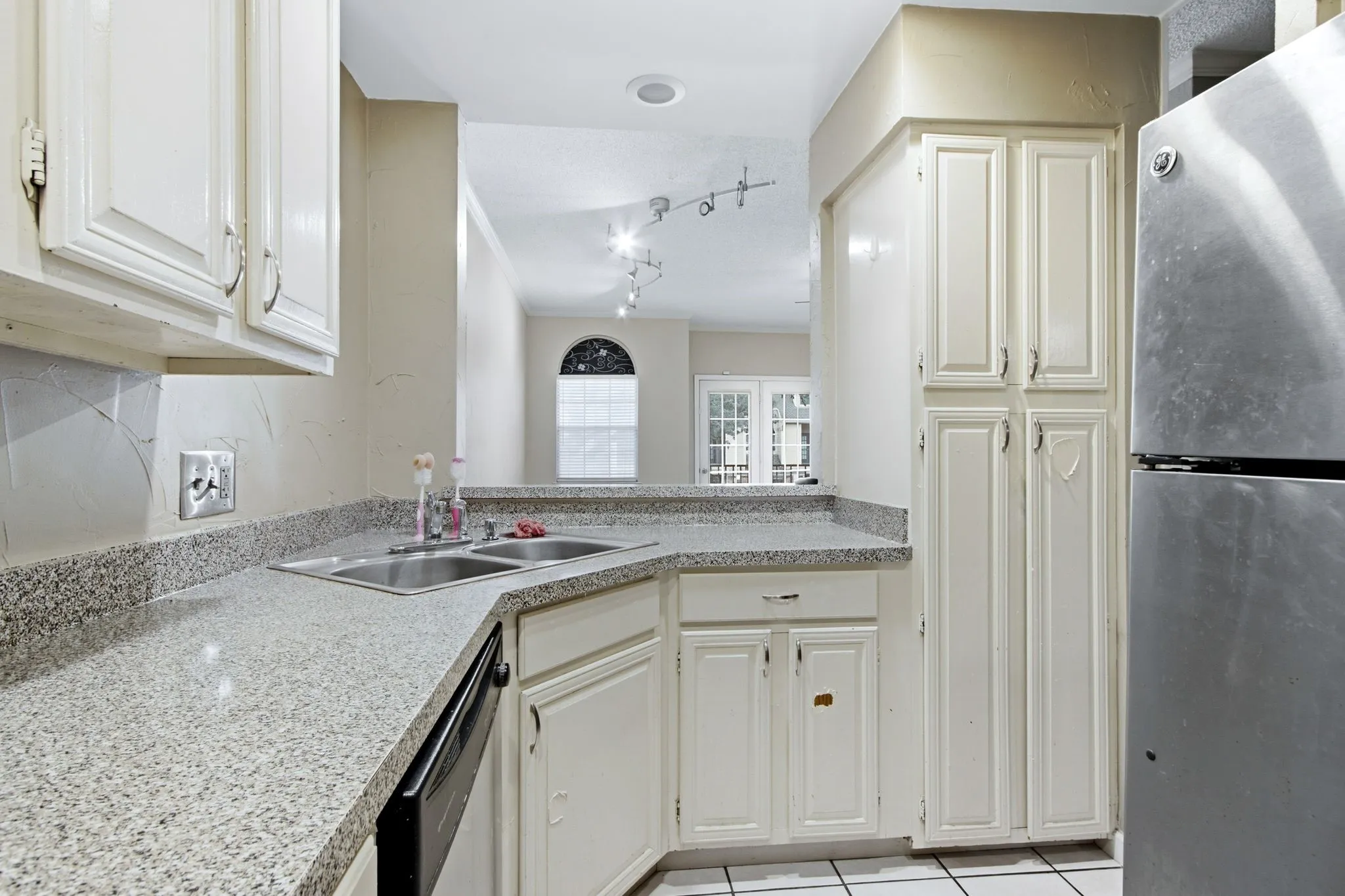 Kitchen featuring granite-look countertops and white cabinetry