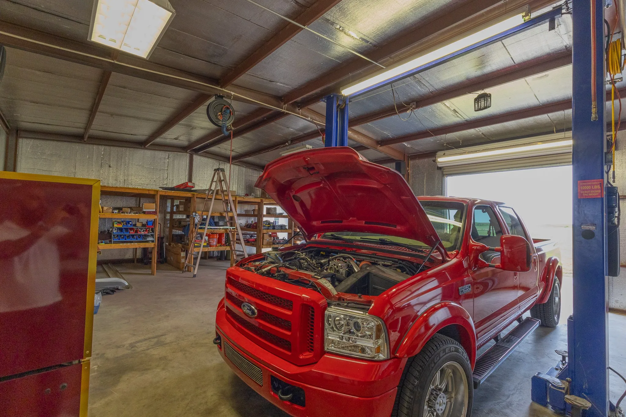 Spacious workshop featuring a durable concrete floor, exposed structural beams, and a high ceiling