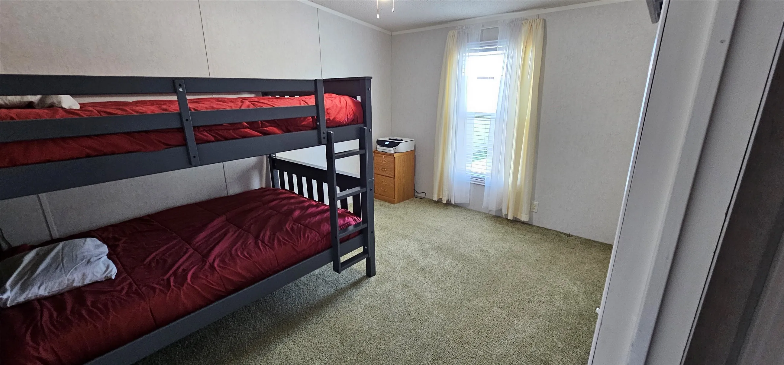 Carpeted room with a single window and ceiling fan
