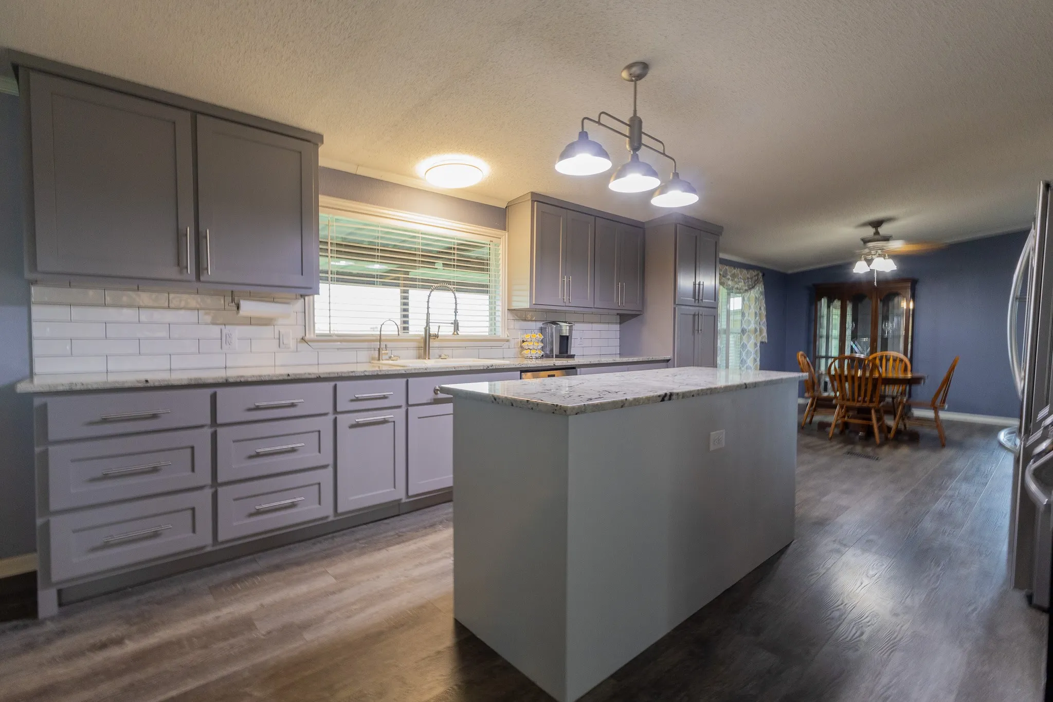 Updated kitchen featuring gray cabinetry and a central island with a light-toned countertop