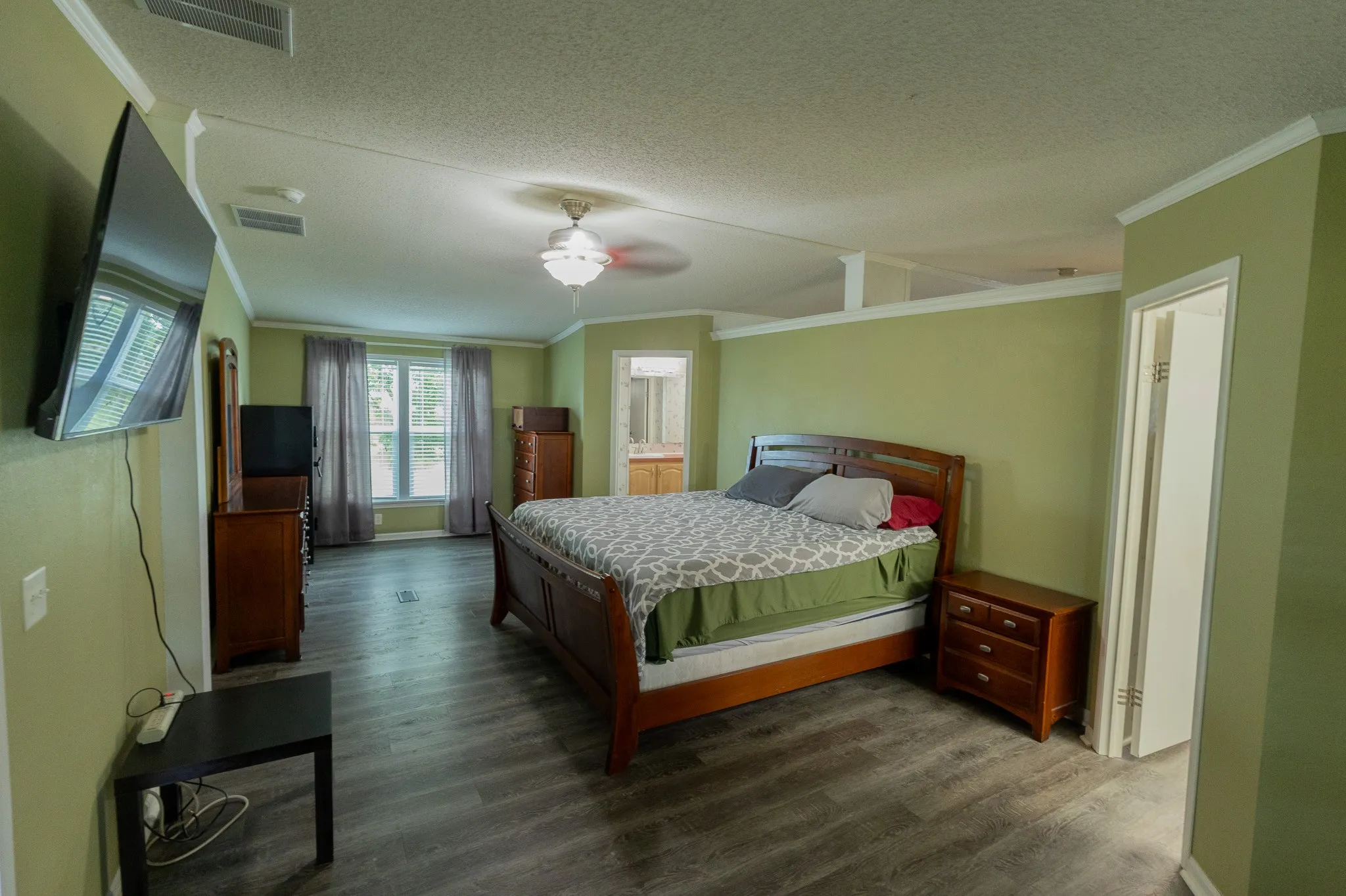 Spacious room featuring wood-finish flooring and a ceiling fan