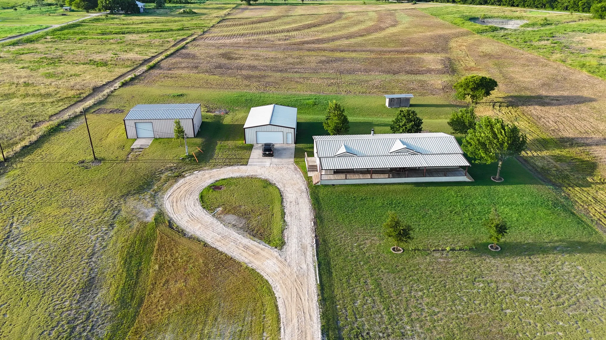 Expansive property featuring a single-story residence with a covered porch and metal roof