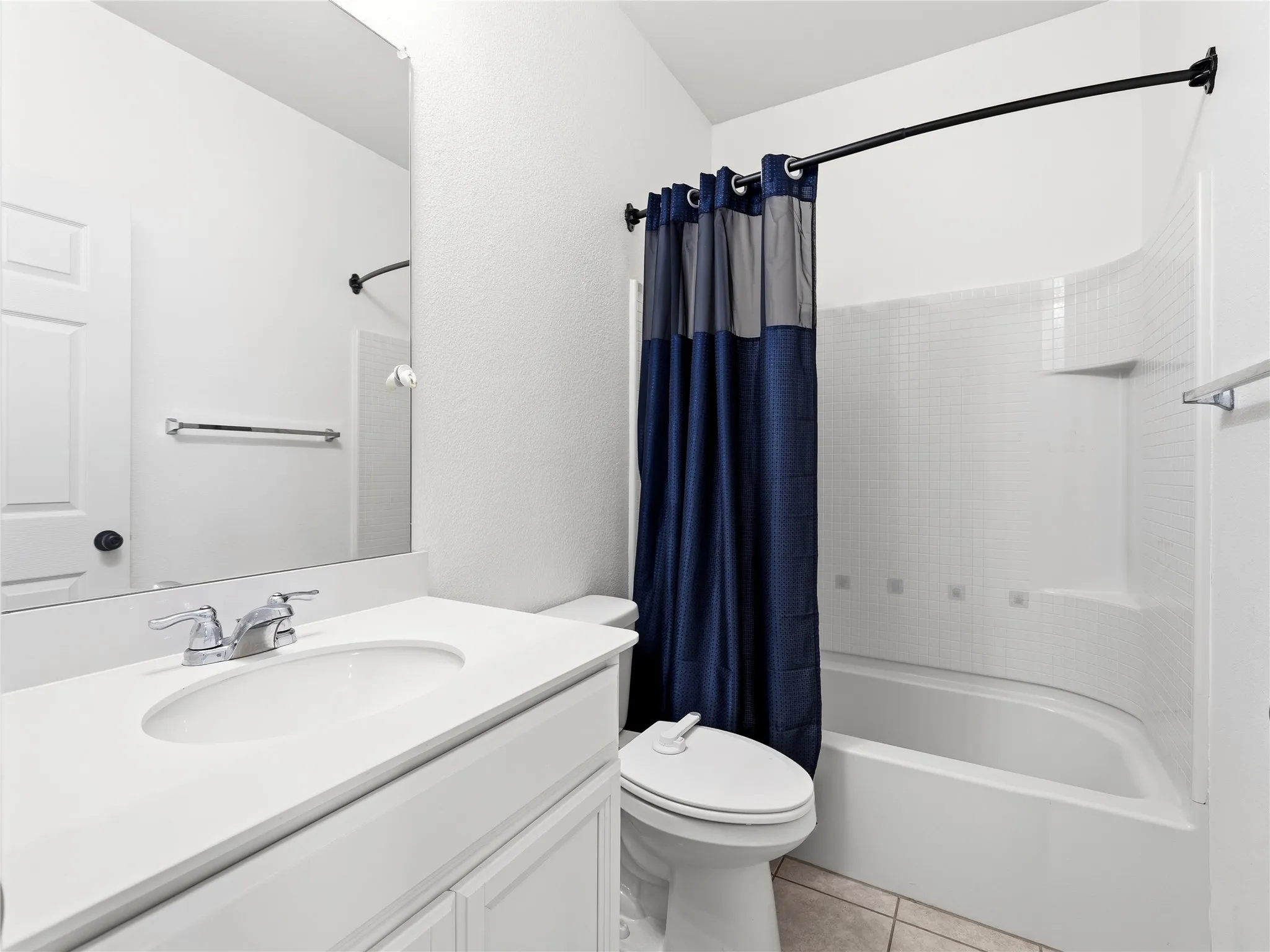 Bathroom featuring a white vanity with an integrated sink, chrome faucet, and full-width mirror