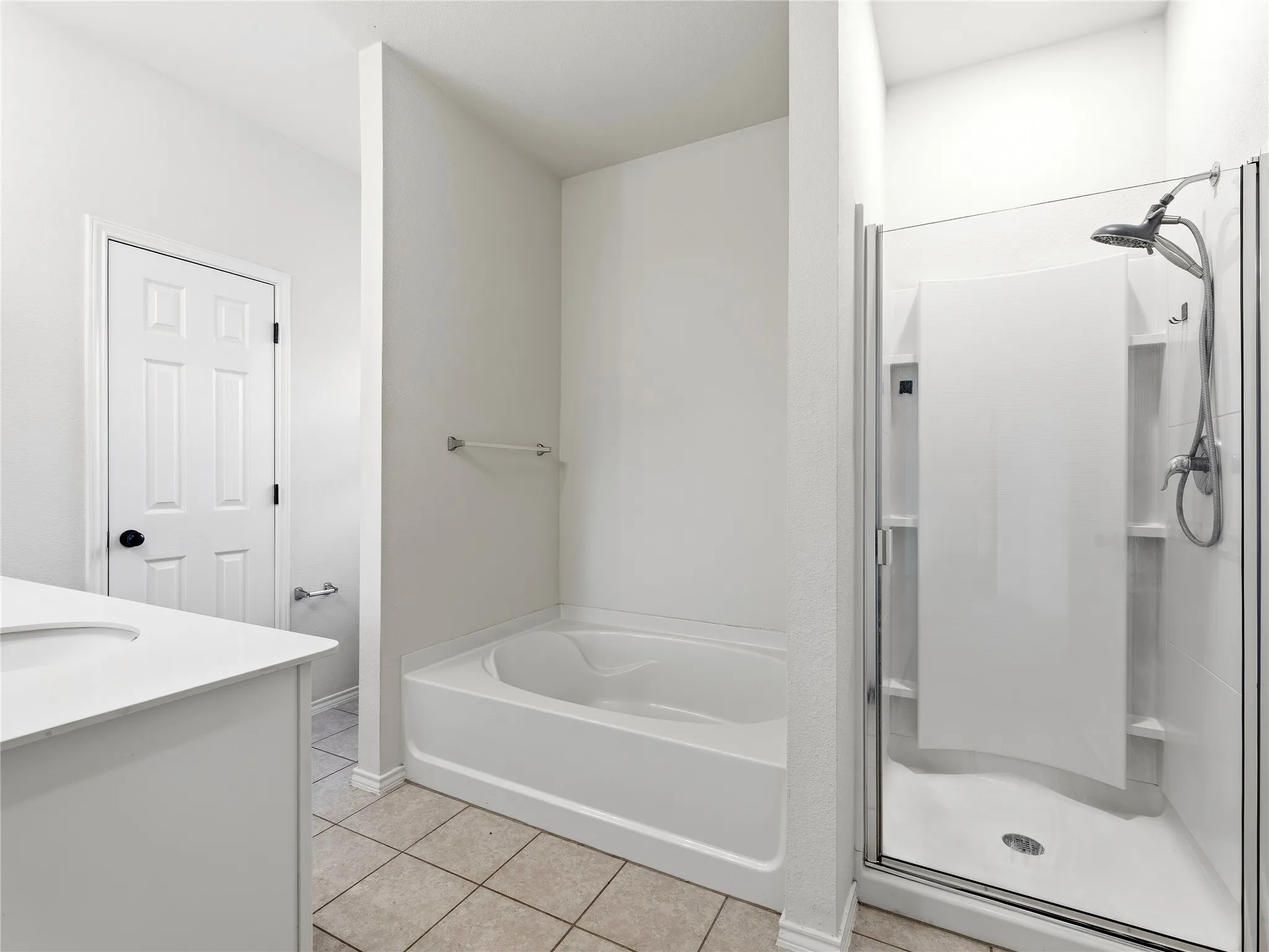 Bathroom with a white vanity, integrated sink, and an enclosed shower with a glass door