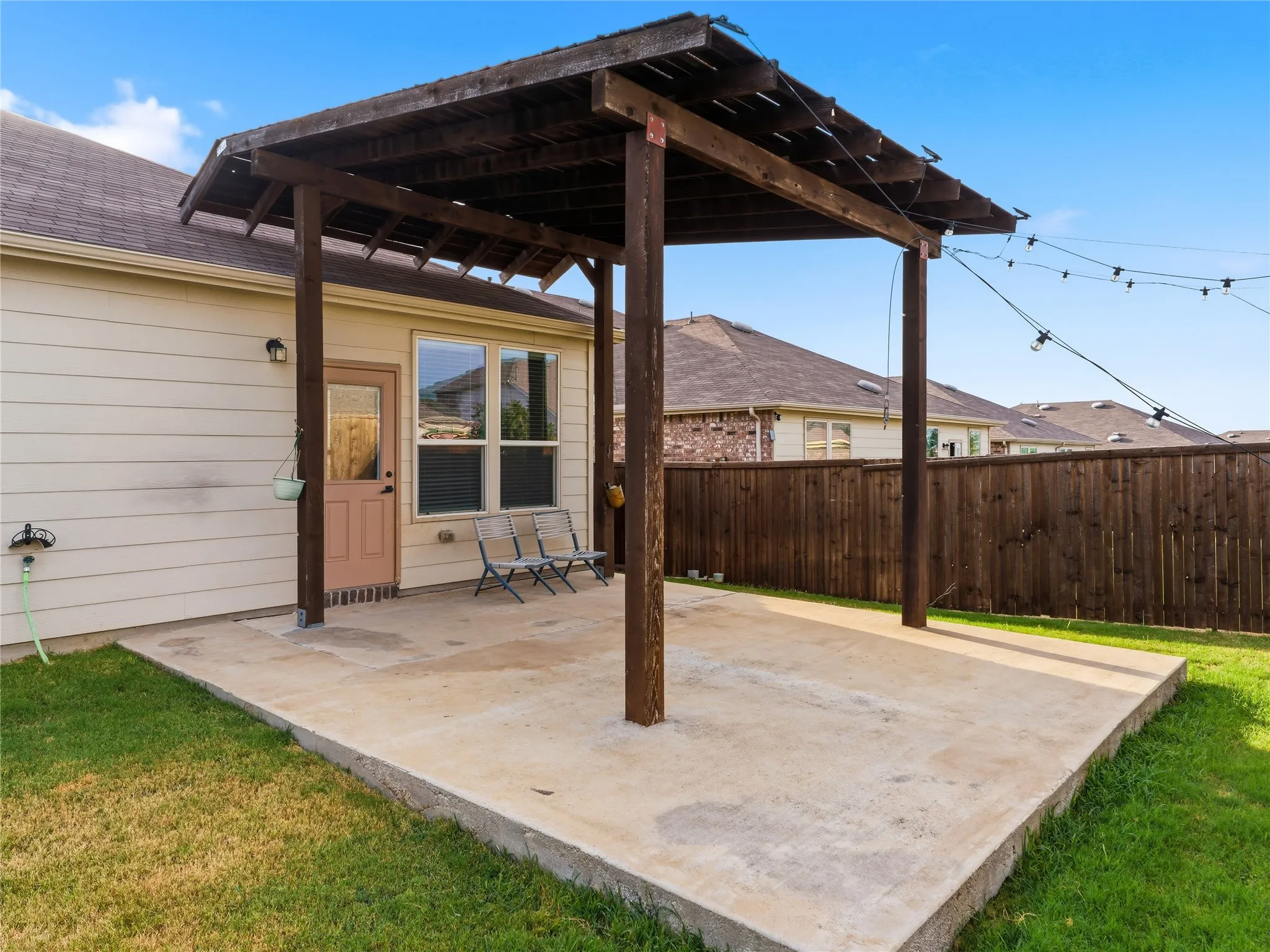 Concrete patio featuring a wooden pergola