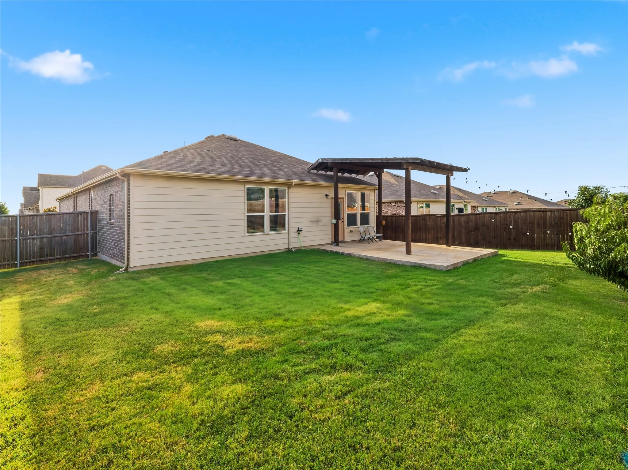 Expansive green lawn with a privacy fence surrounding the property