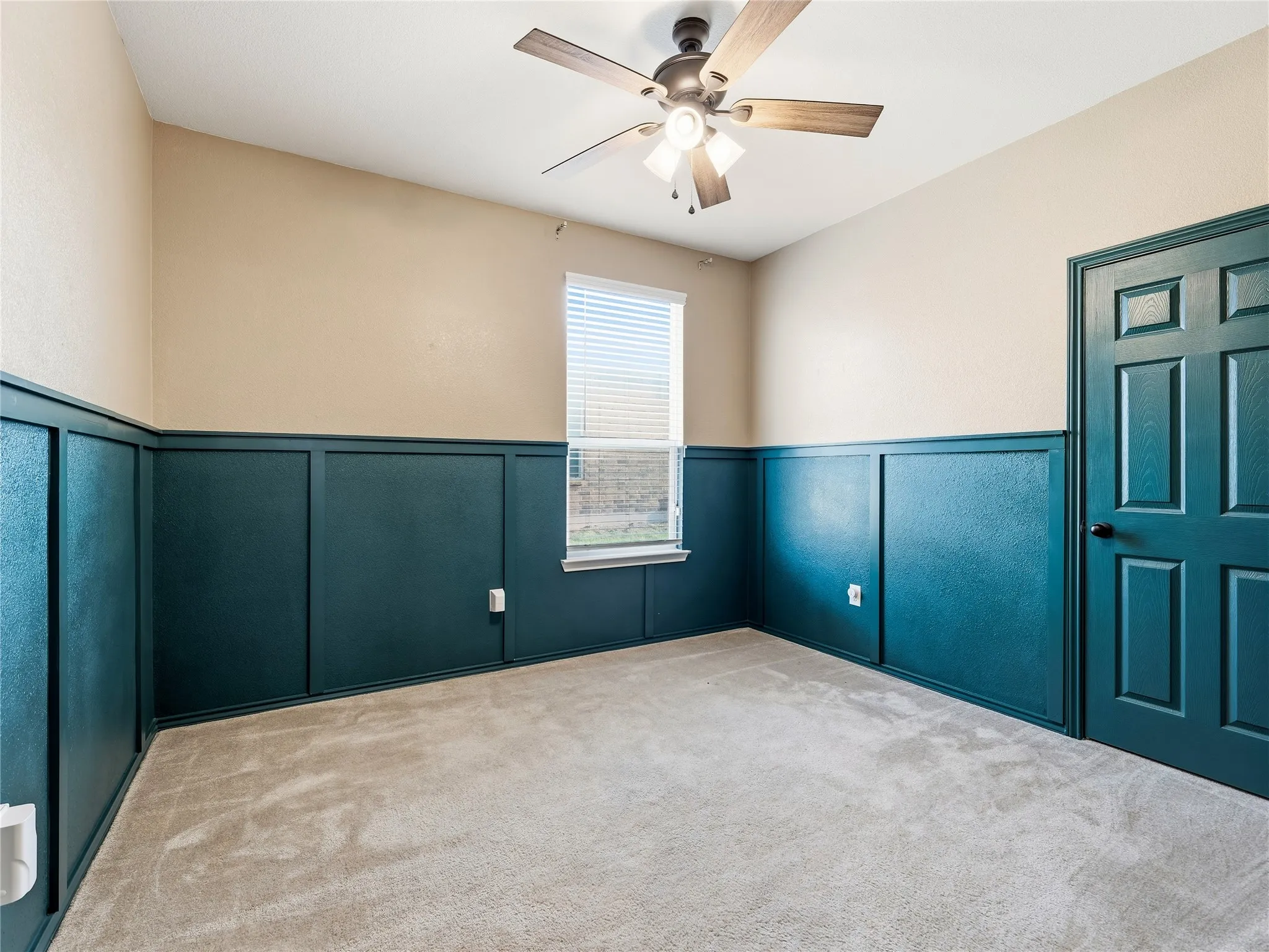 Room with angled ceiling, carpet flooring, a ceiling fan with light fixture, and a window with blinds