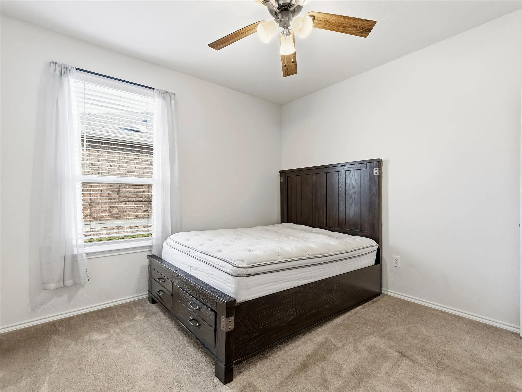 Neutral-toned carpeted flooring with a single pane window featuring blinds