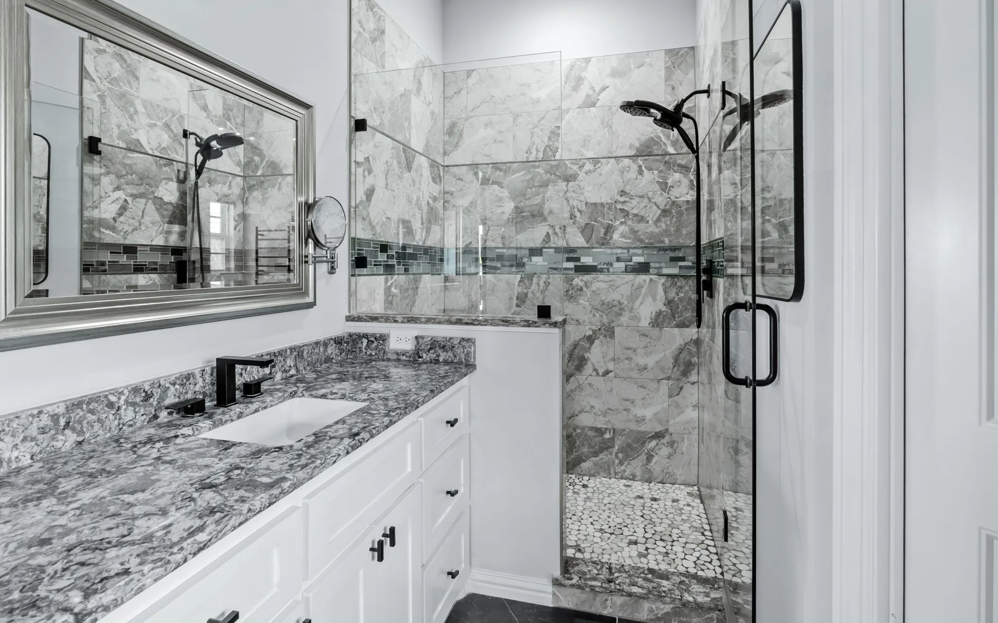 Modern bathroom featuring a spacious vanity with a stone countertop and integrated sink