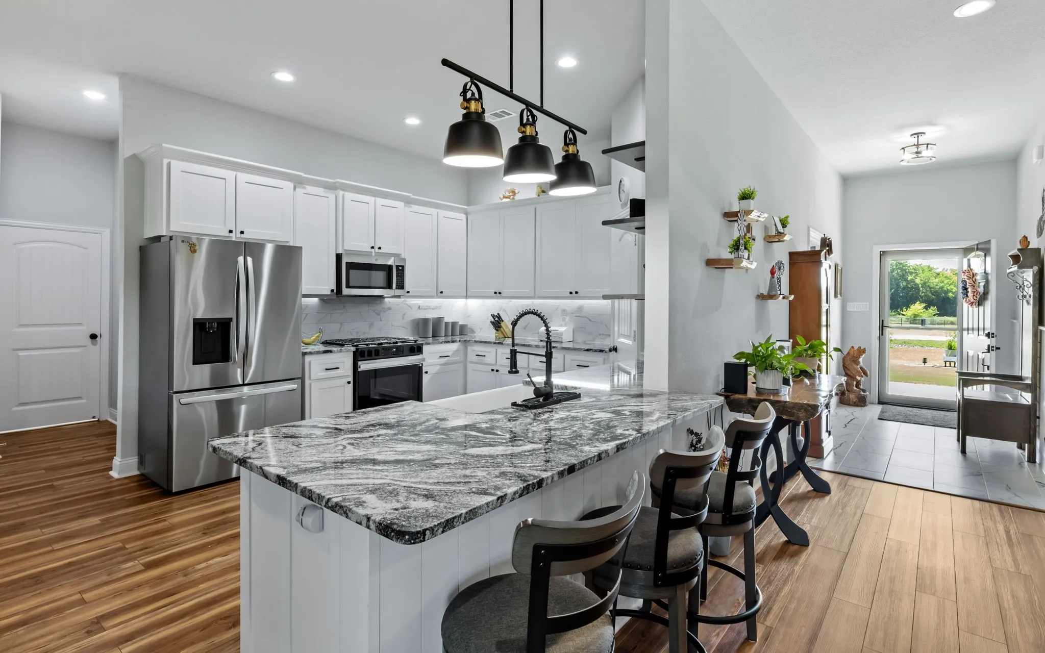 Kitchen with stainless steel appliances, a large island and  pendant lighting