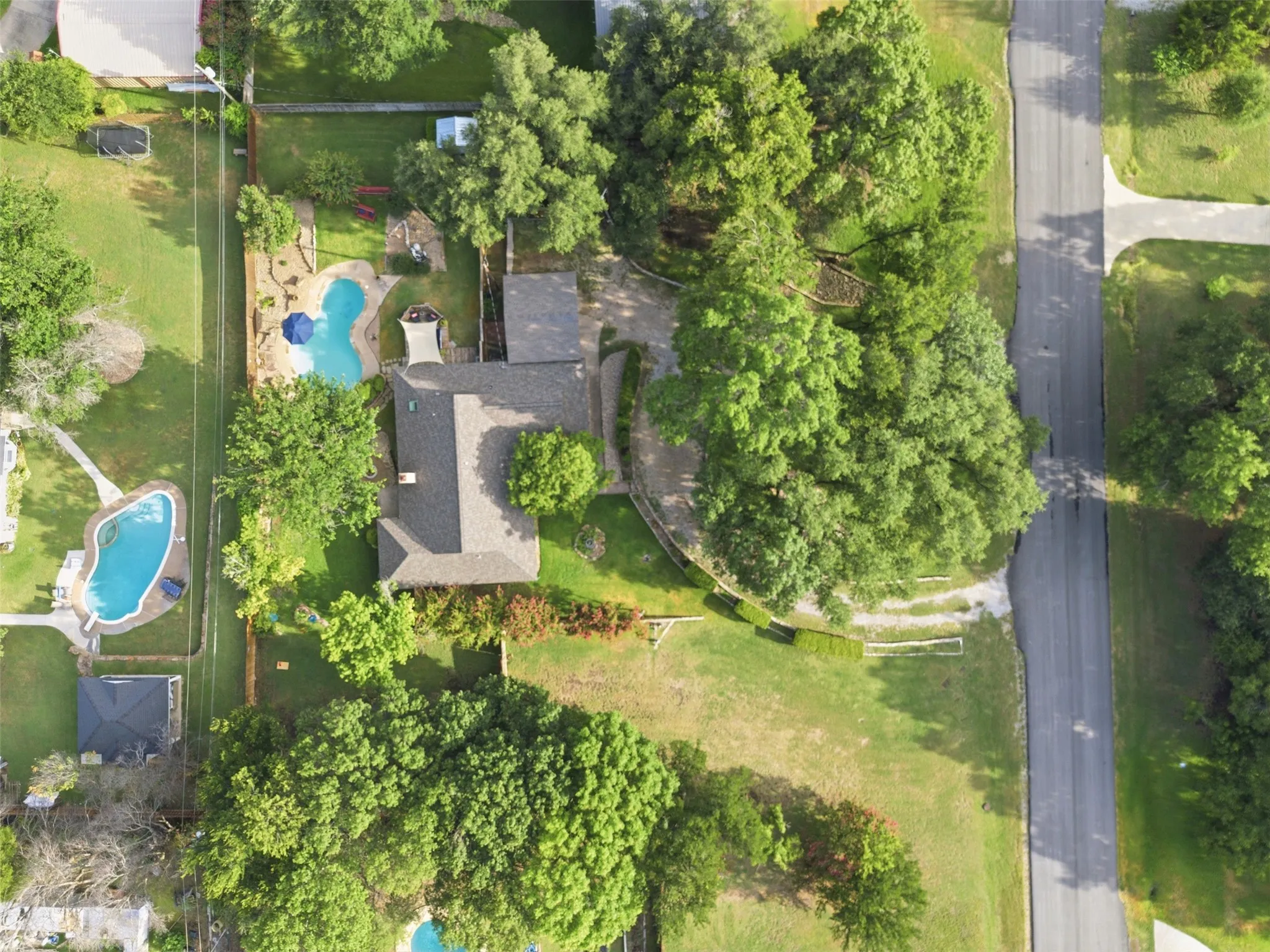 Aerial perspective highlighting a large residential property with a dark shingle roof