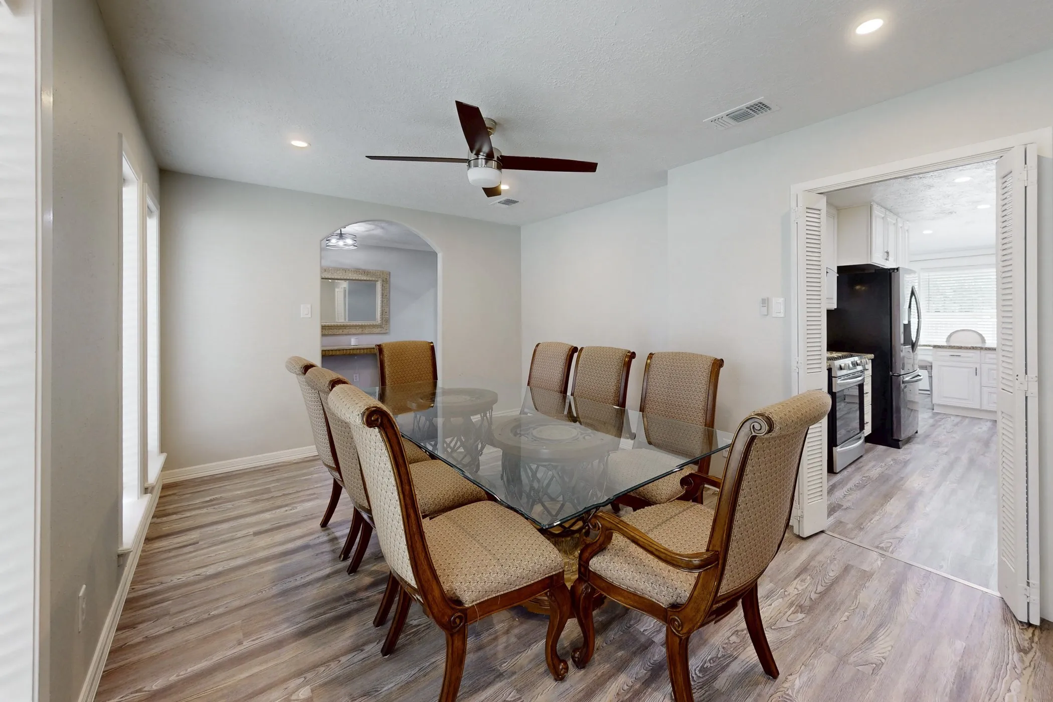 Spacious dining area featuring wood-finish flooring, recessed lighting, and a ceiling fan