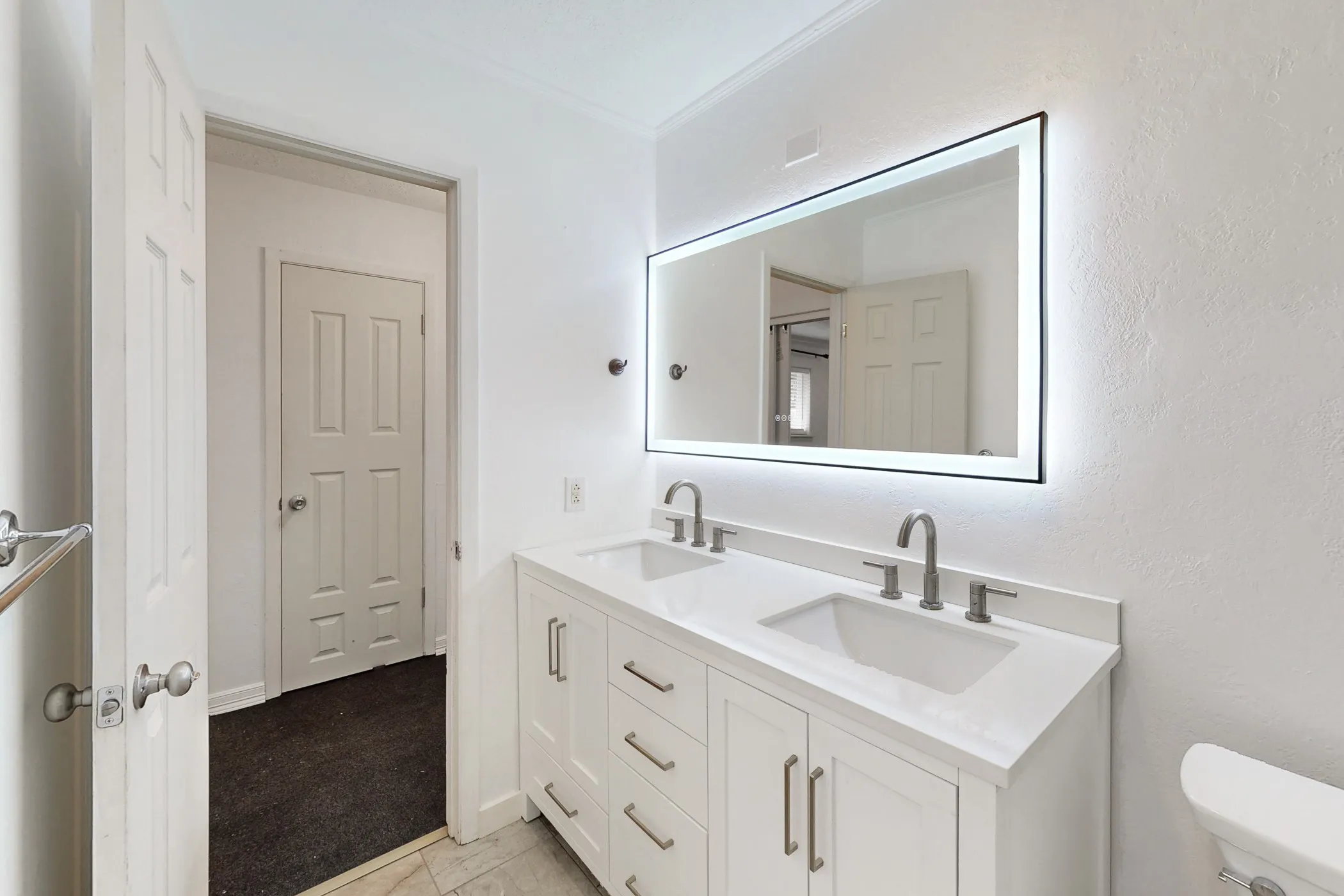 Double vanity with white cabinetry, under-mount sinks, and a quartz countertop