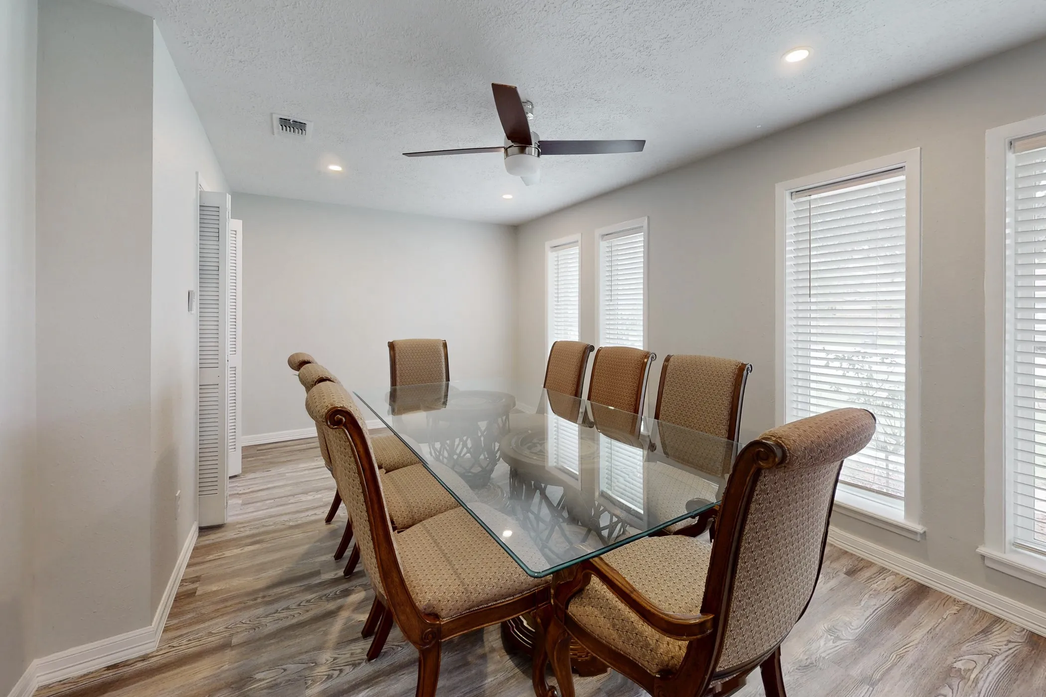Spacious interior room featuring wood-finish flooring, light gray wall paint, and white trim