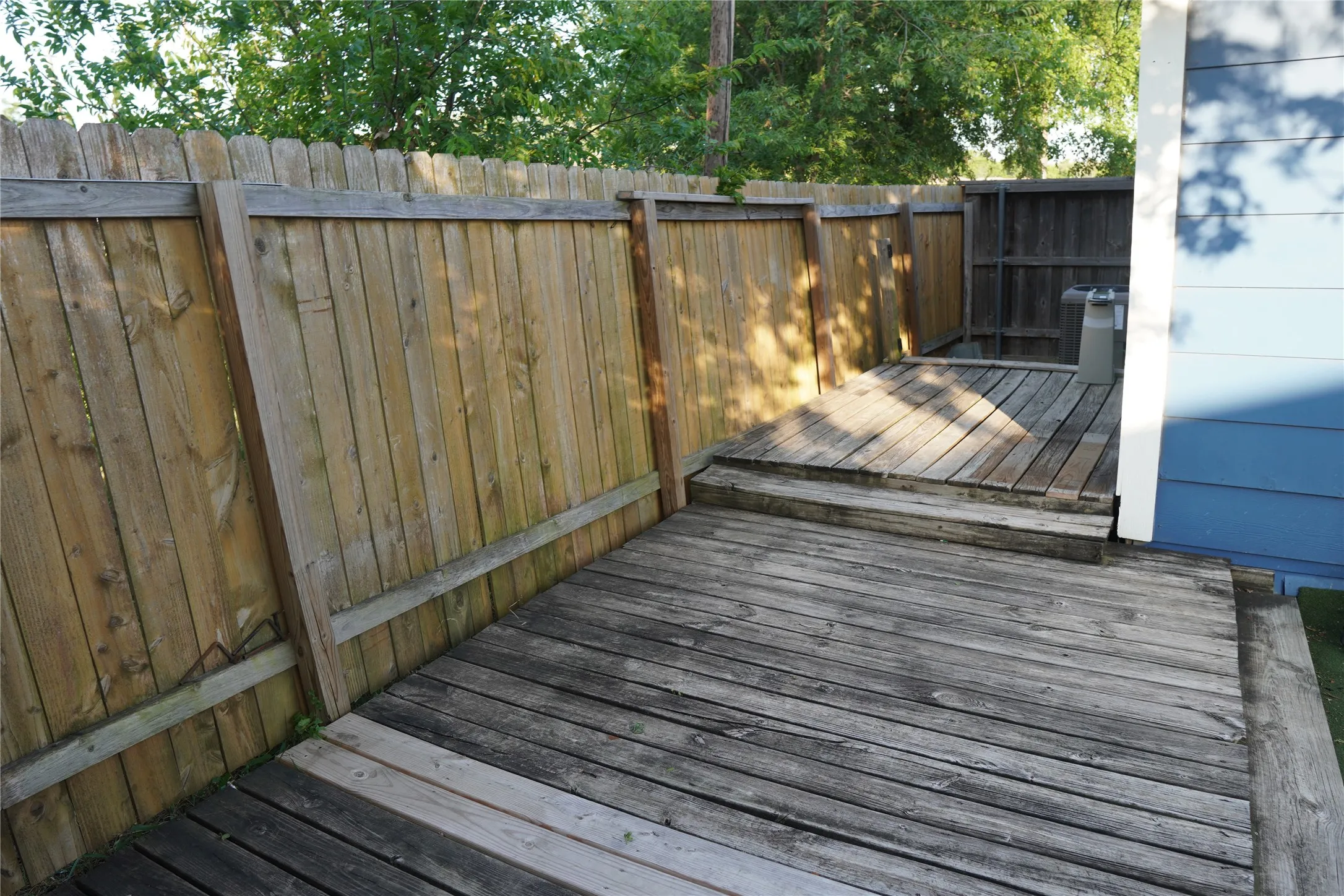 Multi-level wood deck area with surrounding privacy fencing