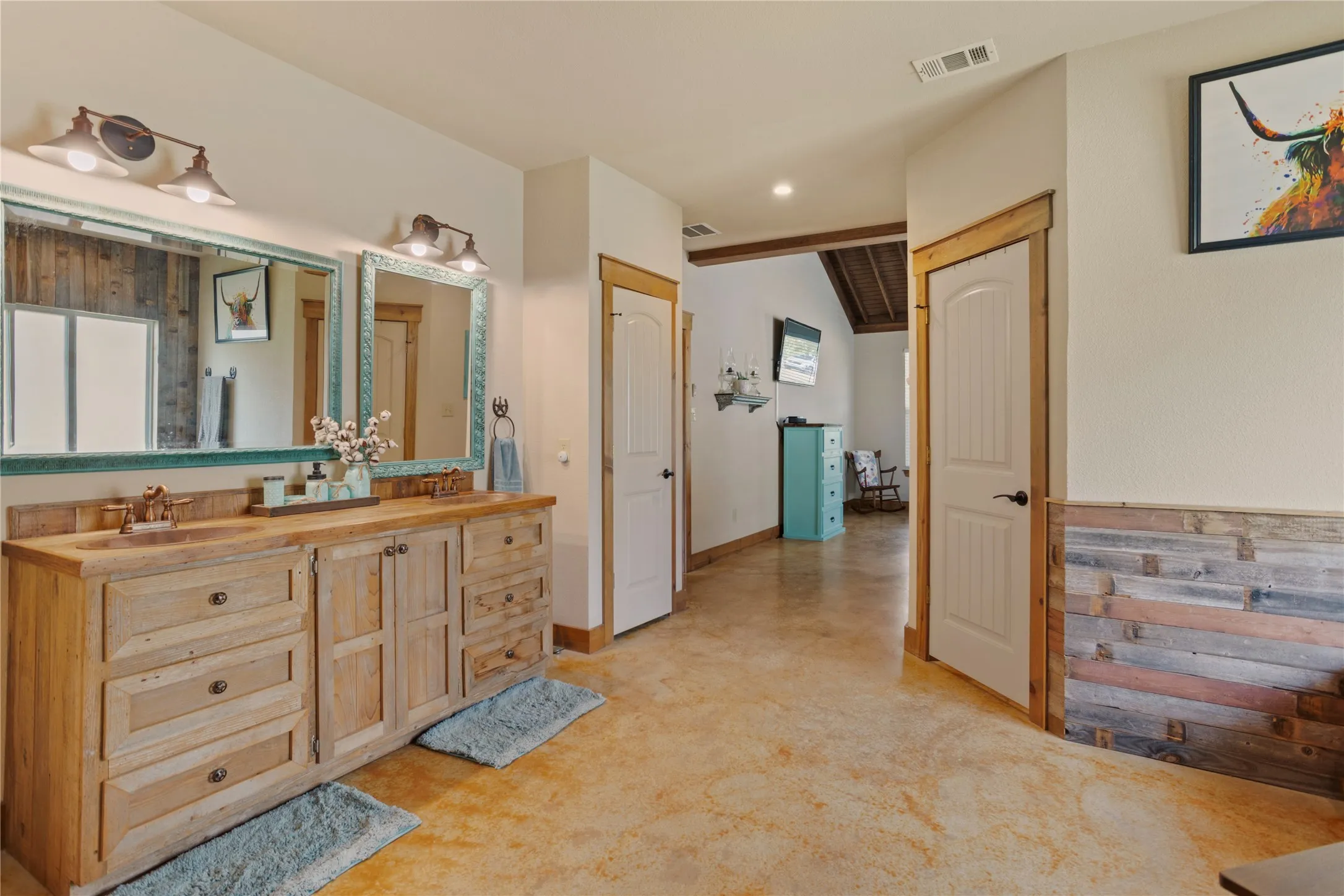Double vanity with wood-finish cabinetry, dual vessel sinks, and bronze-tone fixtures