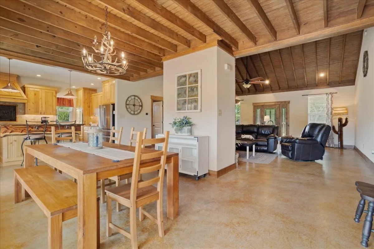 Open-concept interior featuring exposed wood-beam ceilings and polished concrete flooring