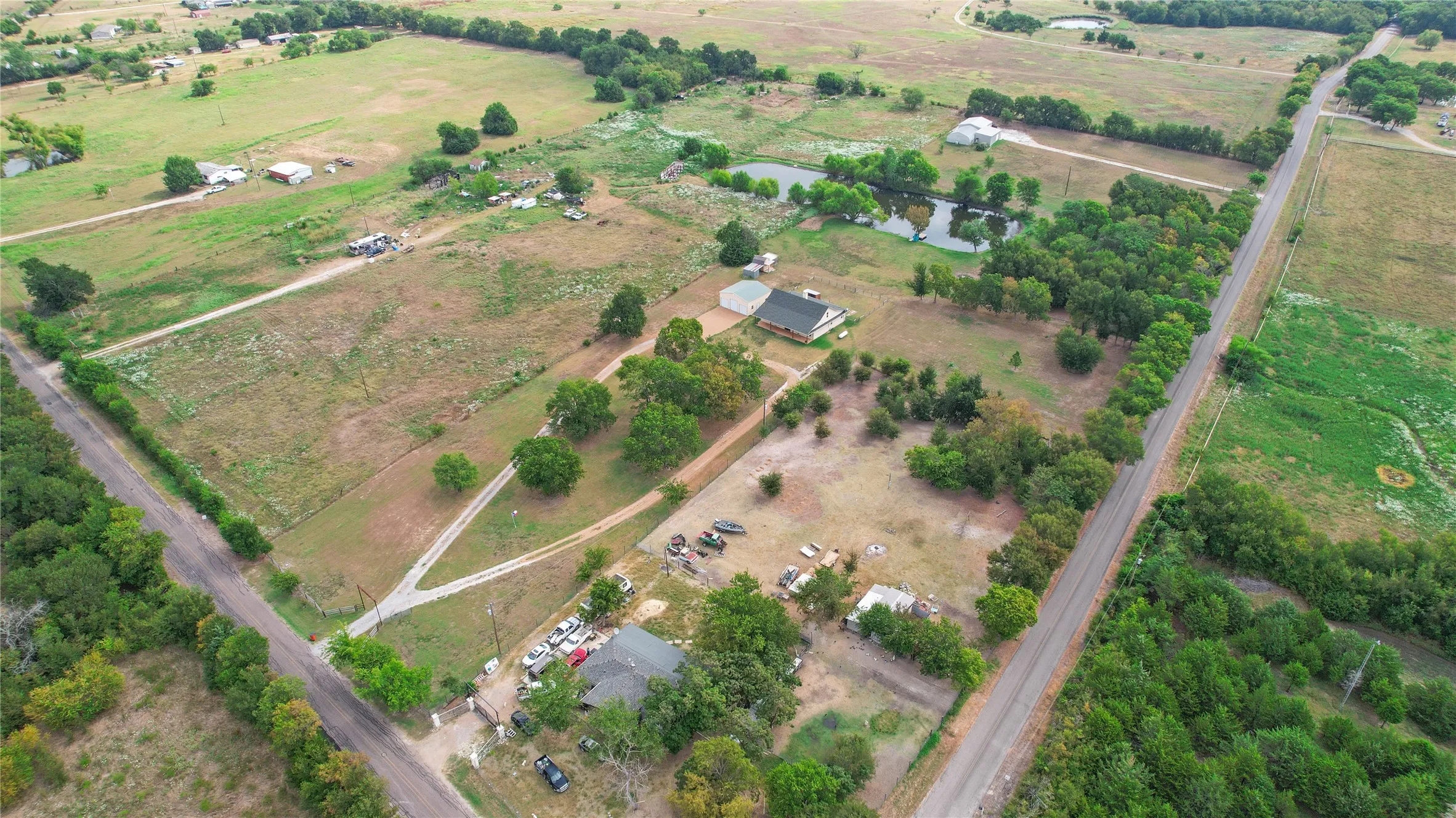 Expansive rural land featuring multiple parcels, scattered trees, and two distinct ponds