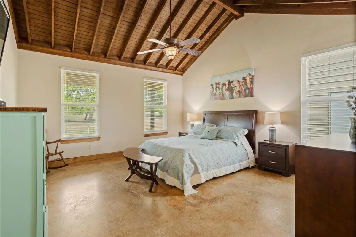 Vaulted wood-plank ceiling with exposed beams and a ceiling fan